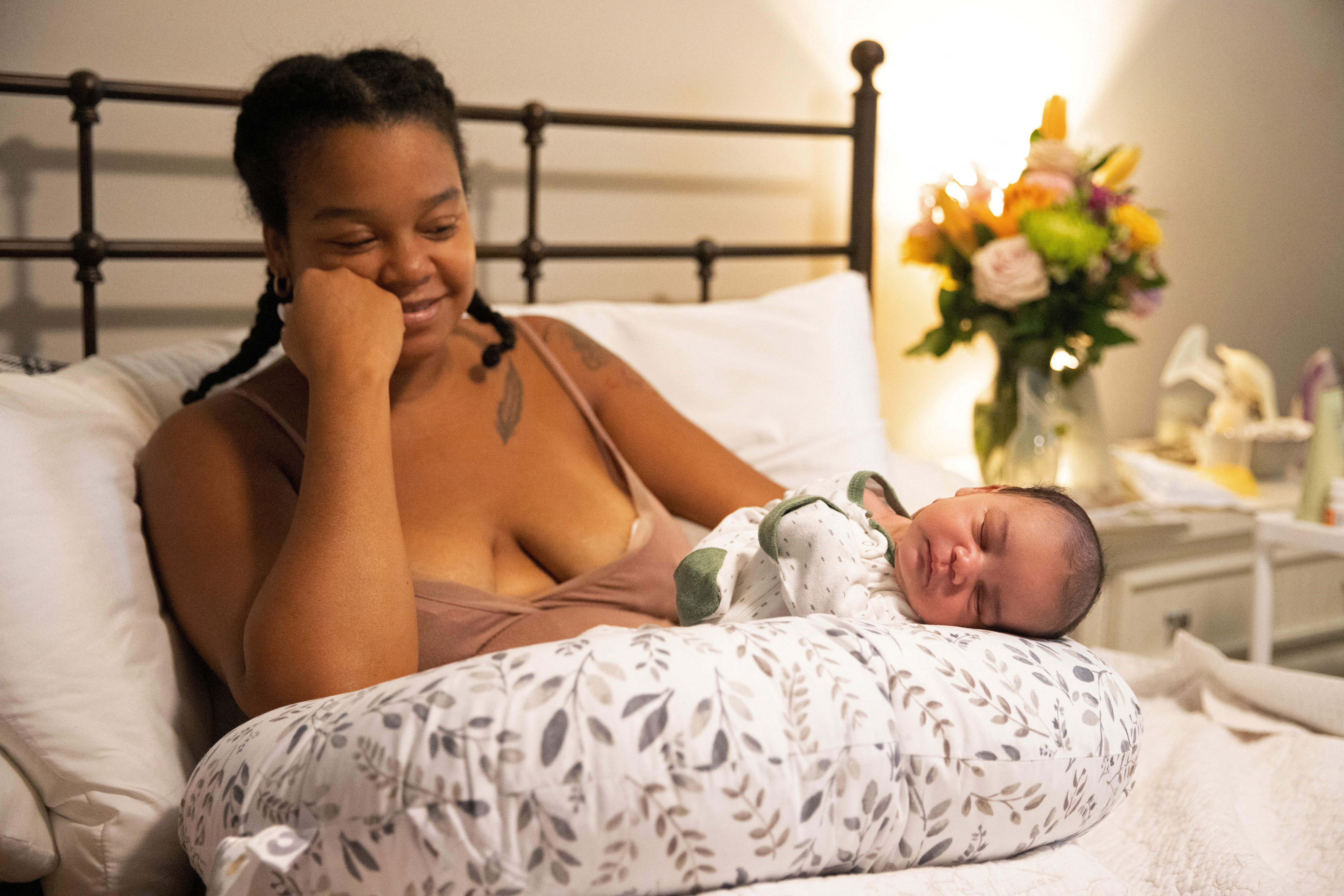 Holistic doula Ciara Clark, 34, looks lovingly at Evan, her sleeping newborn, in Toms River, New Jersey, U.S., September 18, 2022. REUTERS/Joy Malone