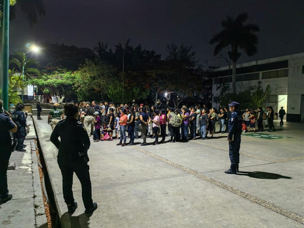 Members of the National Institute of Migration (INM) and police officer are monitoring close to migrants after finding 175 migrants, mostly from Guatemala, crowded into a truck trailer in the southern state of Chiapas, when it was stopped at a checkpoint in Chiapas, Mexico, according to the INM statement, in this photo released on May 26, 2023 and distributed by INM. INM/Handout via REUTERS