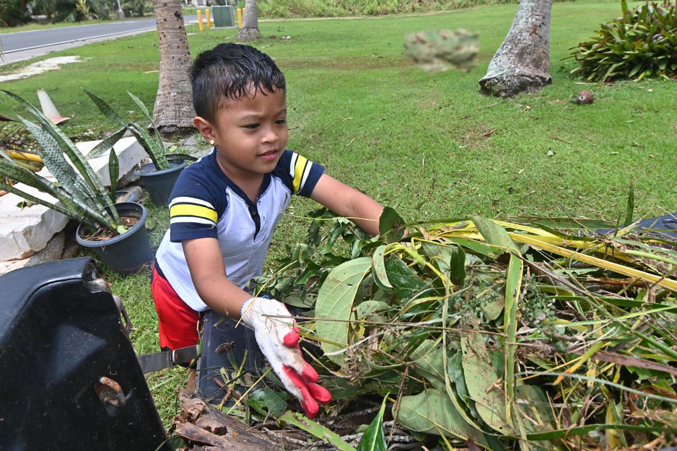 Kallem Diaz, 5, helps clean his grandparents' yard Thursday, May 25, 2023, in Malojloj.  
