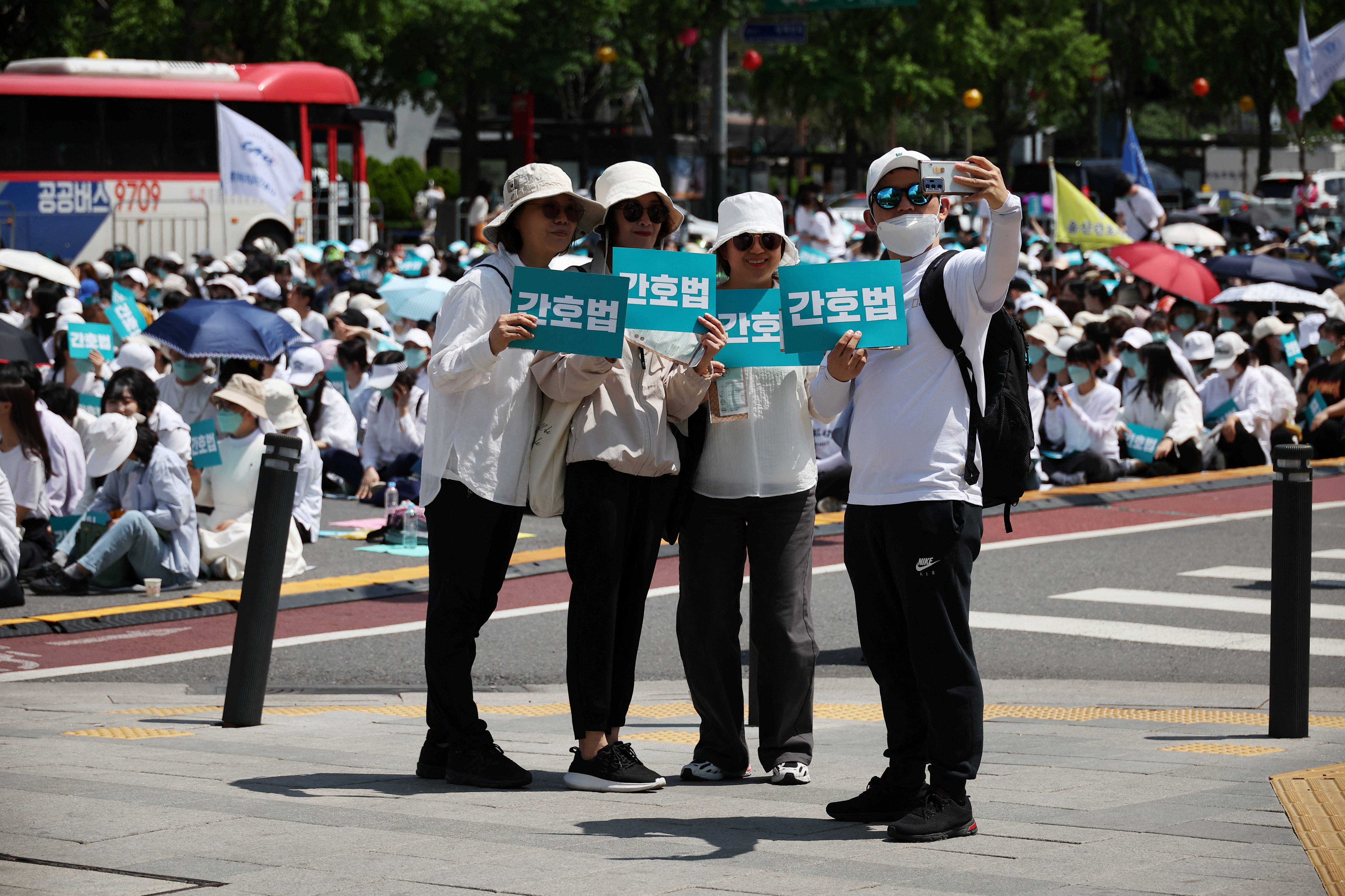 Participants take selfie with signs that read "Nurse act", as nurses and university students majoring in nursing take part in a protest against President Yoon Suk Yeol vetoing a nursing act that defines the roles and responsibilities of nurses, in Seoul, South Korea, May 19, 2023. REUTERS/Kim Hong-Ji