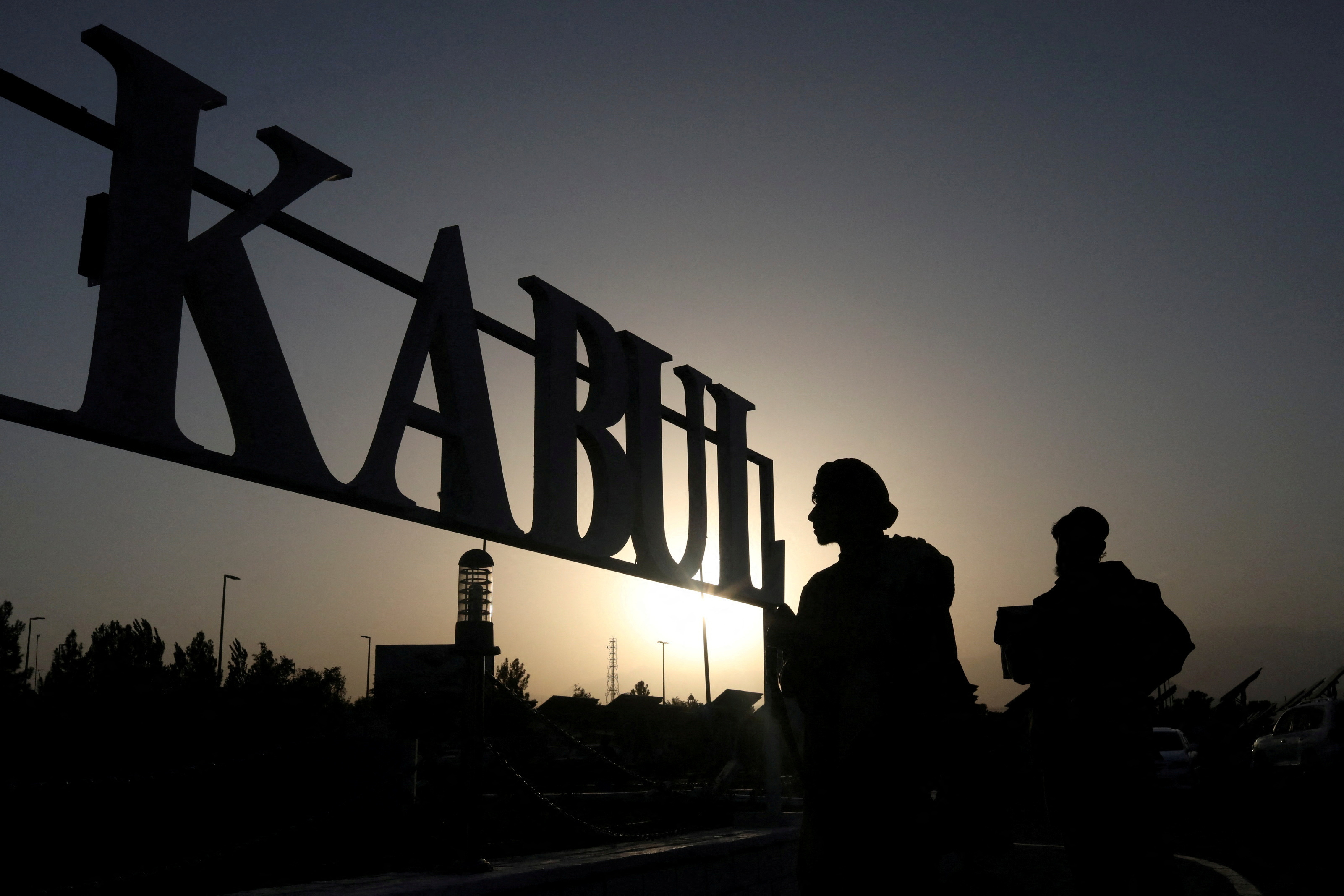 FILE PHOTO: Taliban soldiers stand in front of a sign at the international airport in Kabul, Afghanistan, September 9, 2021. WANA (West Asia News Agency) via REUTERS/File Photo