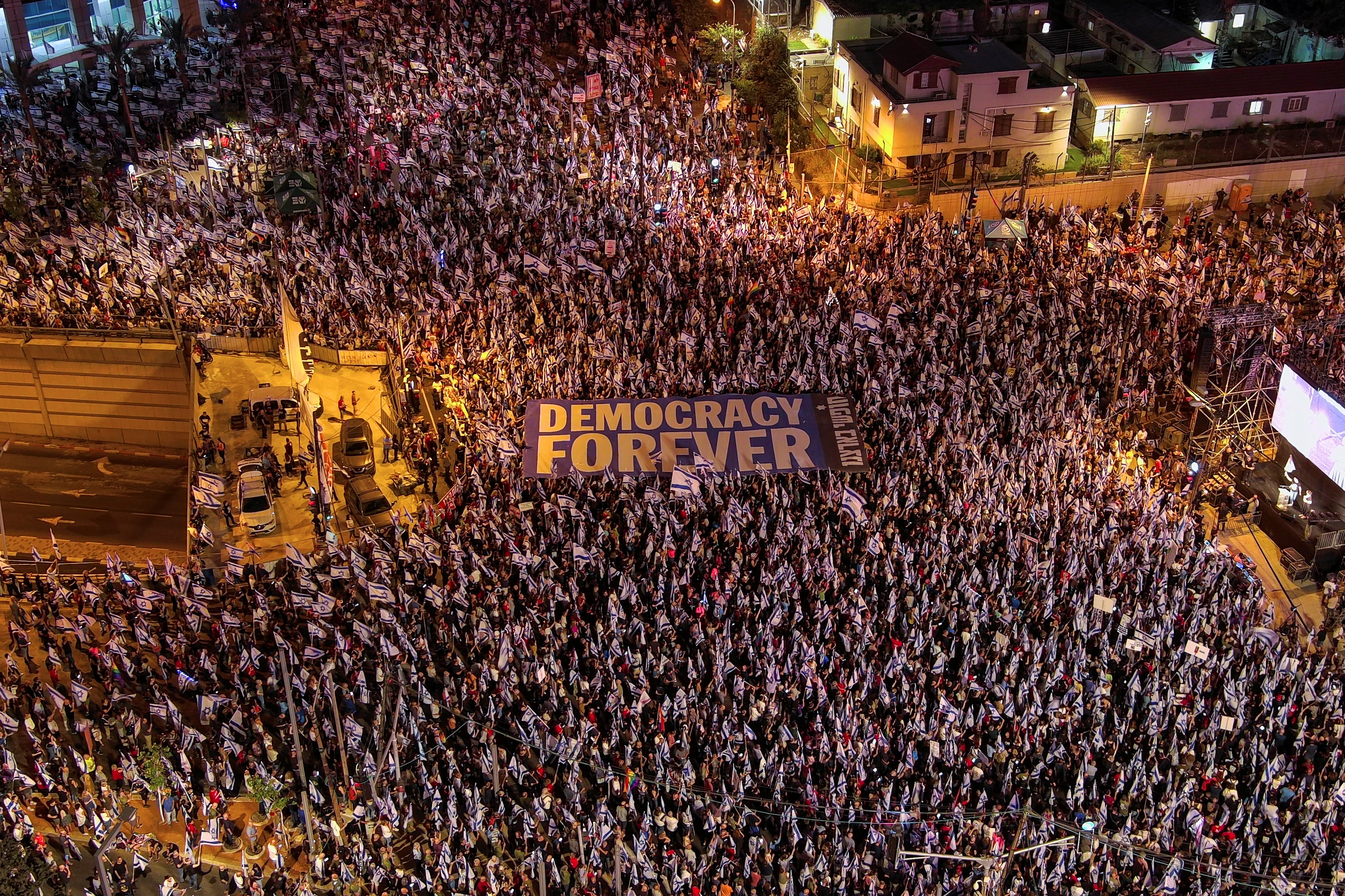 An aerial view shows protesters holding a sign with the words "Democracy Forever" as they attend a demonstration against Israeli Prime Minister Benjamin Netanyahu and his nationalist coalition government's judicial overhaul, in Tel Aviv, Israel May 27, 2023. REUTERS/Ilan Rosenberg