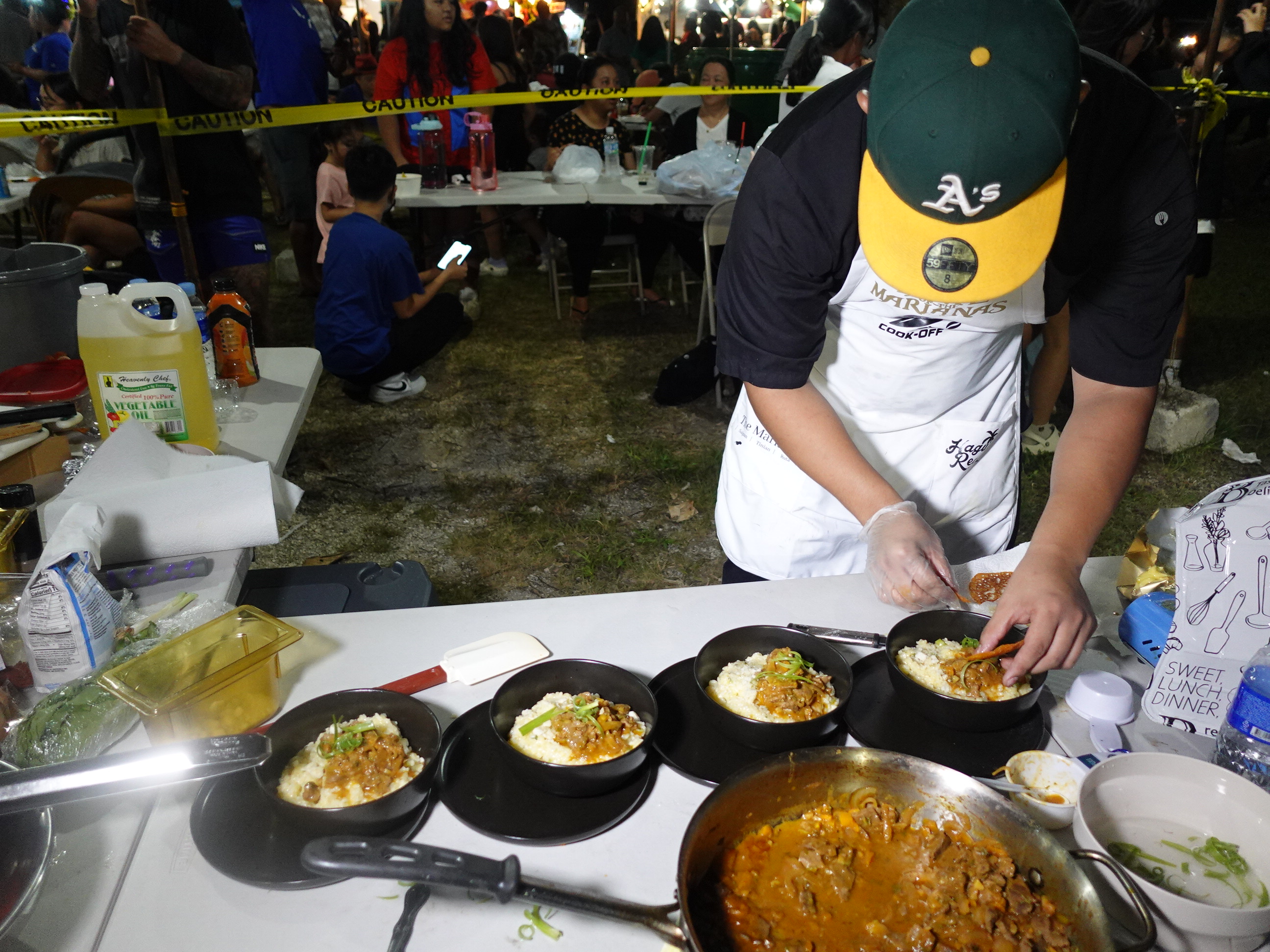 Jonathan Borja, 2nd place winner in the Hotel Association of the Northern Mariana Islands/NMTech Chamorro Bisteak Cookoff on June 24, 2023, puts the finishing touches on his dish, served with risotto. The cookoff was held as part of the 24th Annual Taste of the Marianas International Food Festival & Beer Garden.