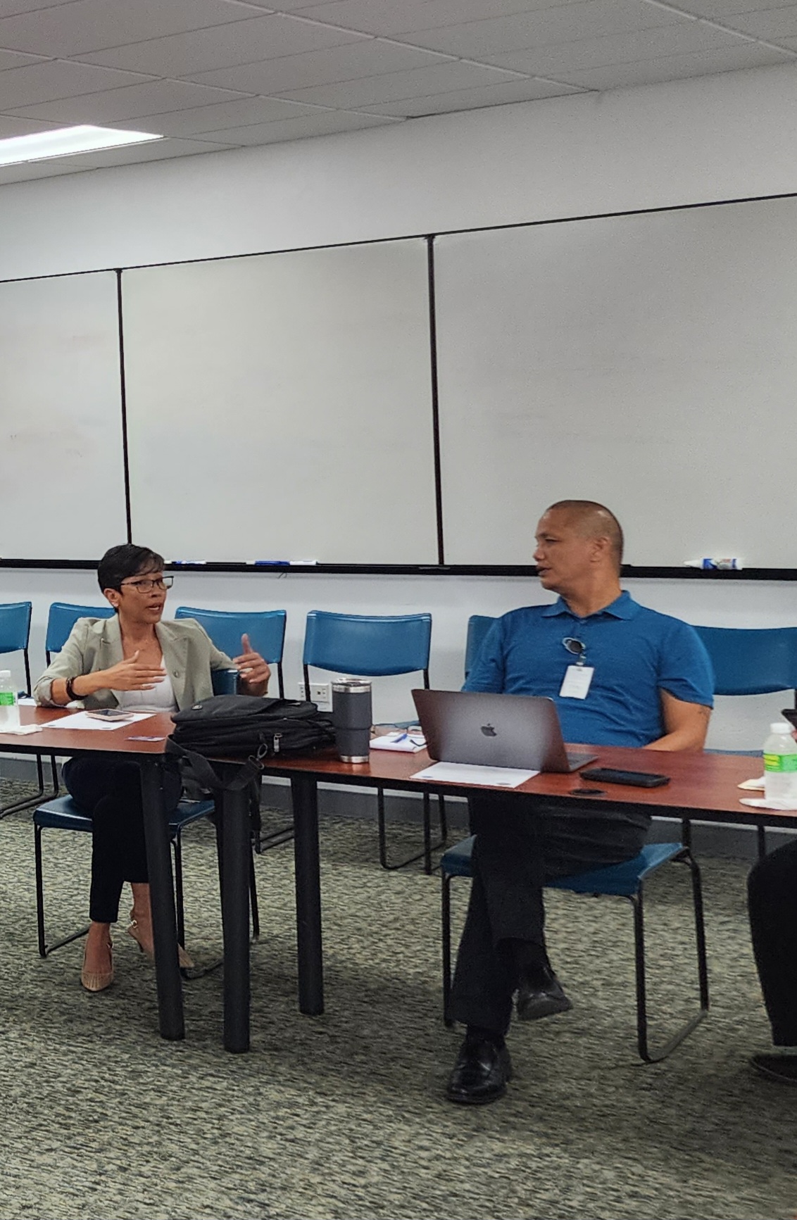 Rep. Marissa Flores, left, gestures as she talks to Rep. Vince Seman Aldan in the Commonwealth Utilities Cor. conference room during a break from a CUC board meeting Friday morning.