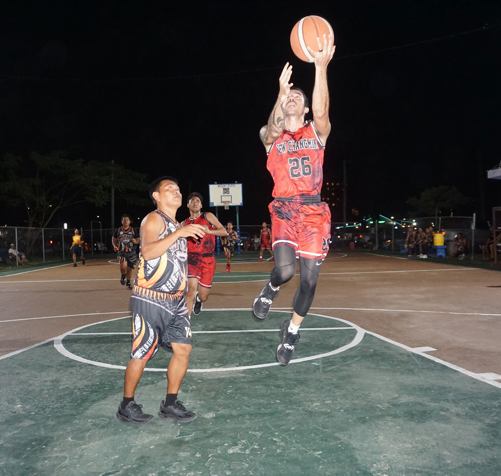 New Chang Ming's Don Brennan finishes at rim after evading a defender during the quarterfinal game against JTM Saipan in the Saipan Centennial Lions Club Invitational Basketball League Friday at the Civic Center basketball court.