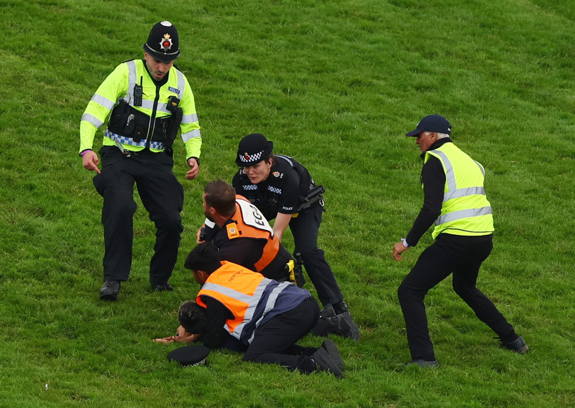 Horse Racing - Epsom Derby Festival - Epsom Downs Racecourse, Epsom, Britain - June 3, 2023 Protestor is removed from the race track by police officers during the 13:30 Betfred Derby Action Images via Reuters/Matthew Childs