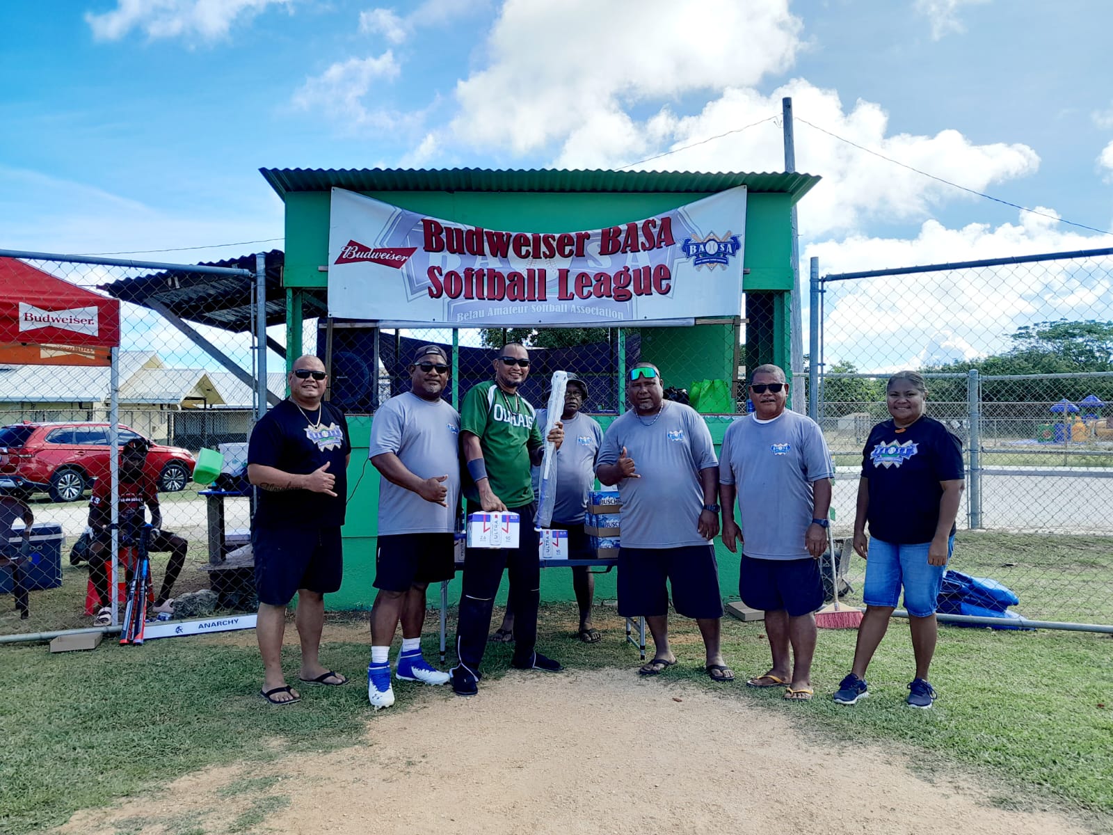 The Budweiser Belau Amateur Softball Association homerun derby winner in the men’s division, Cartfield Sablan, holds his prizes as he poses for a photo with league officials Sunday at the Dandan baseball field.