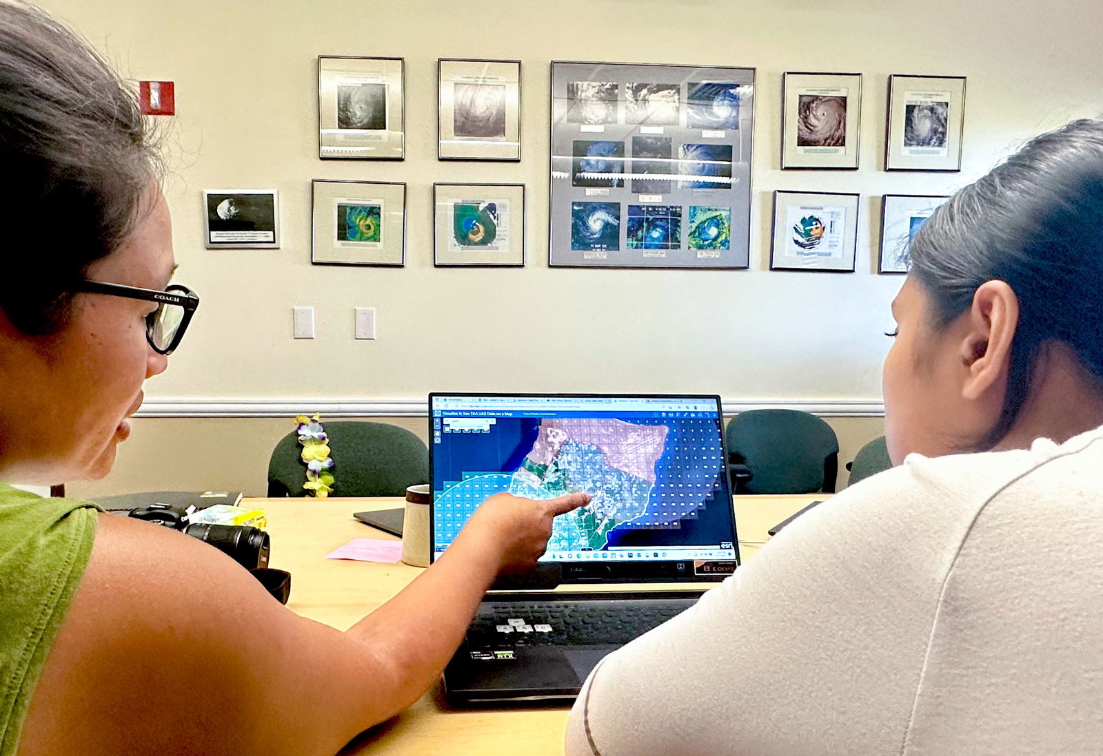NASA Guam Space Grant and NASA Guam EPSCoR Associate Director, Dr. Romina King, and co-remote-pilot-in-command and environmental science graduate student, Jonelle Sayama, look at a map illustrating the various airspace restrictions on Guam during a pre-flight meeting at the National Weather Service Guam Forecast Office in Tiyan, Guam.