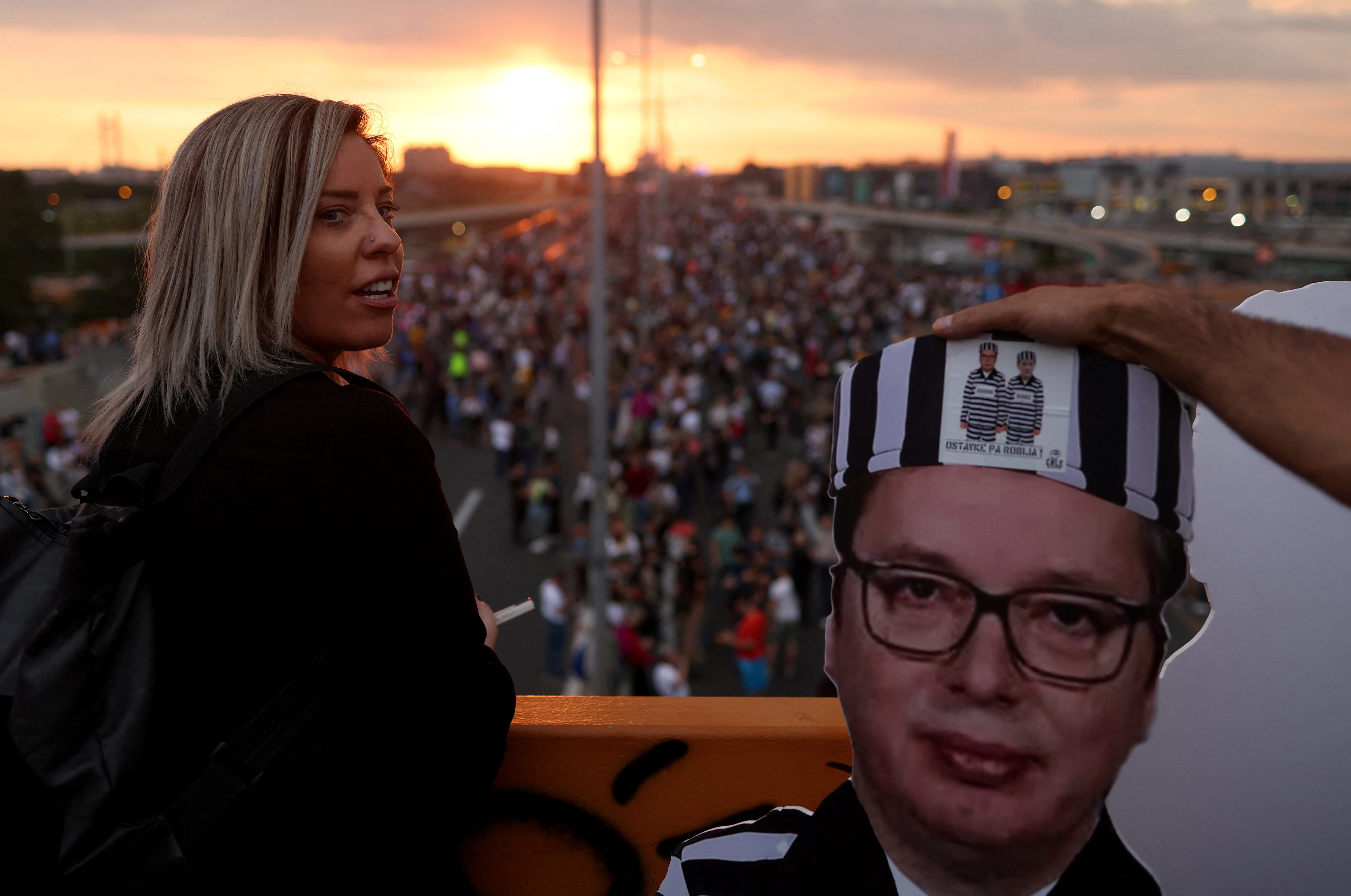 A man holds a board depicting Serbian President Aleksandar Vucic as people attend a demonstration "Serbia against violence" organized by Serbia's opposition parties in reaction to the two mass shootings in the same week, in Belgrade, Serbia, June 17, 2023. REUTERS/Marko Djurica
