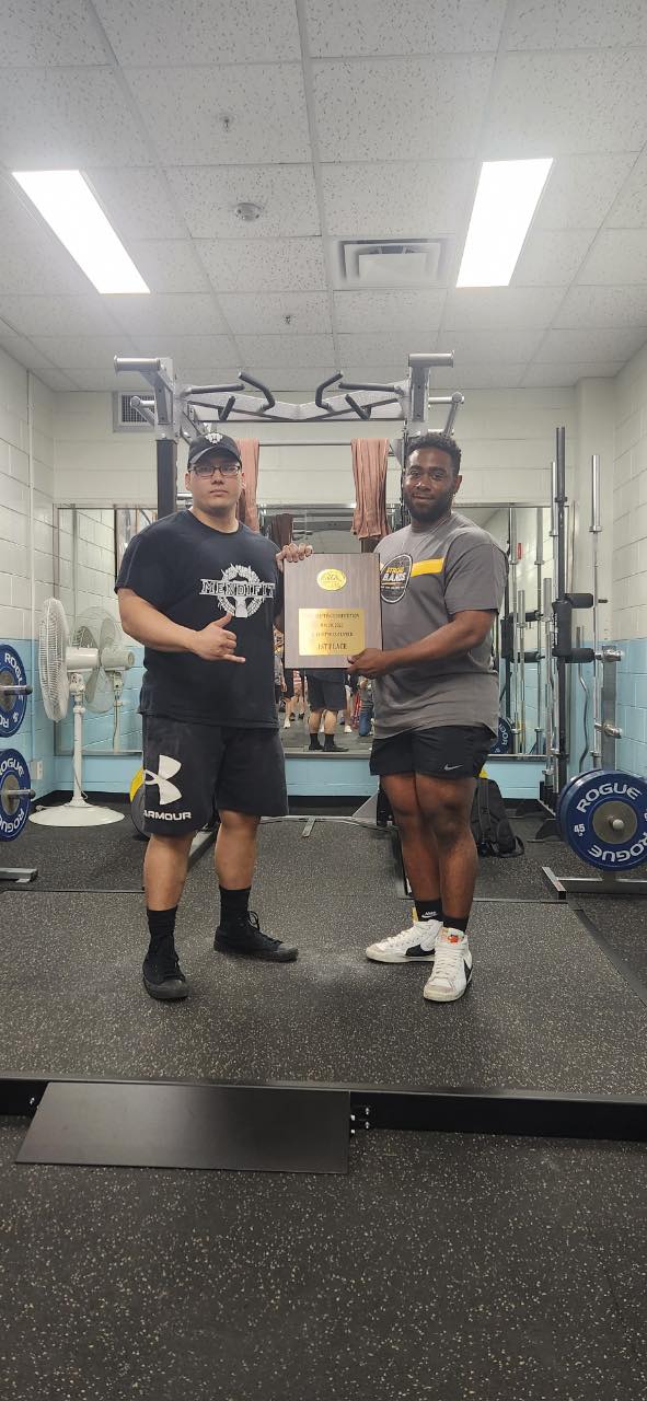 Donivan Mendiola, left, poses with the overall champion plaque after winning a powerlifting event on May 20, 2023 at a U.S. military base in Seoul, South Korea.