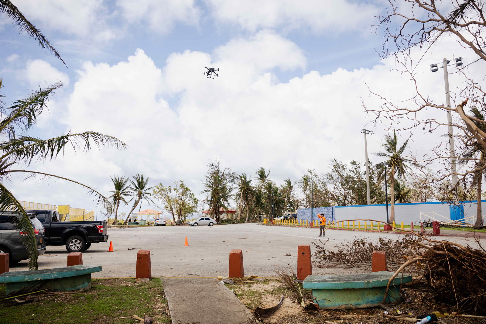 UOG Drone Corps member Kaya Taitano stands in a clearing of fallen tree debris as she monitors a drone to ensure a safe landing during a post-Mawar mapping mission at Paseo Stadium in Hagåtña, Guam on May 27, 2023.
