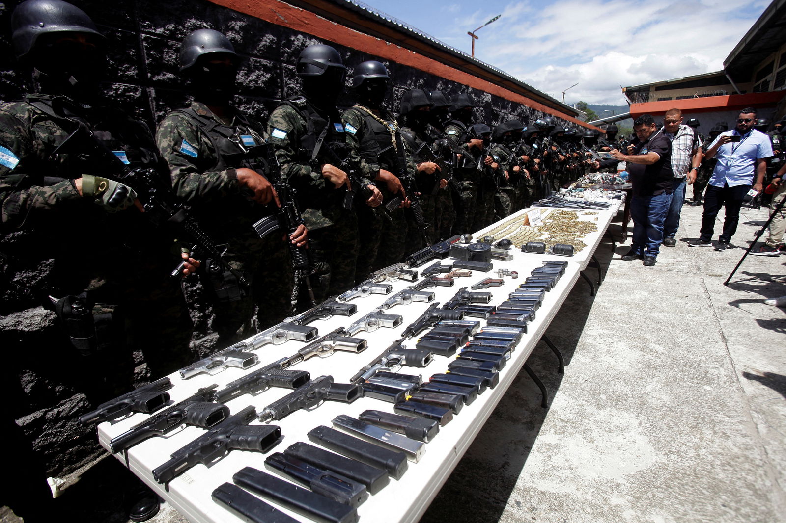 Members of the Military Police of Public Order stand guard as they present bullets, magazines and weapons, seized at Tamara prison after the Honduras Armed Forces took over the control of the prisons nationwide as part of the "Fe y Esperanza" operation, on the outskirts of Tegucigalpa, Honduras June 26, 2023. REUTERS/Fredy Rodriguez