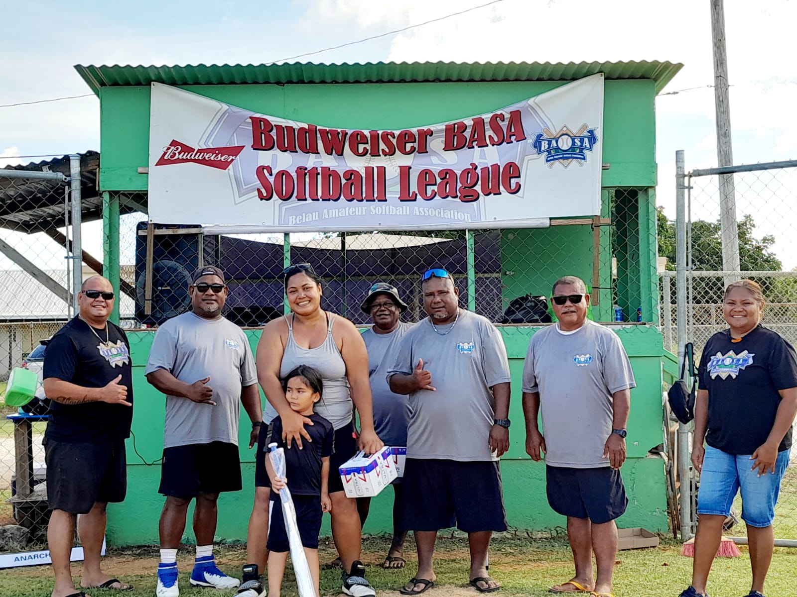 Maribel Igitol, the Budweiser Belau Amateur Softball Association homerun derby winner in the female division, poses for a photo with league officials Sunday at the Dandan baseball field.