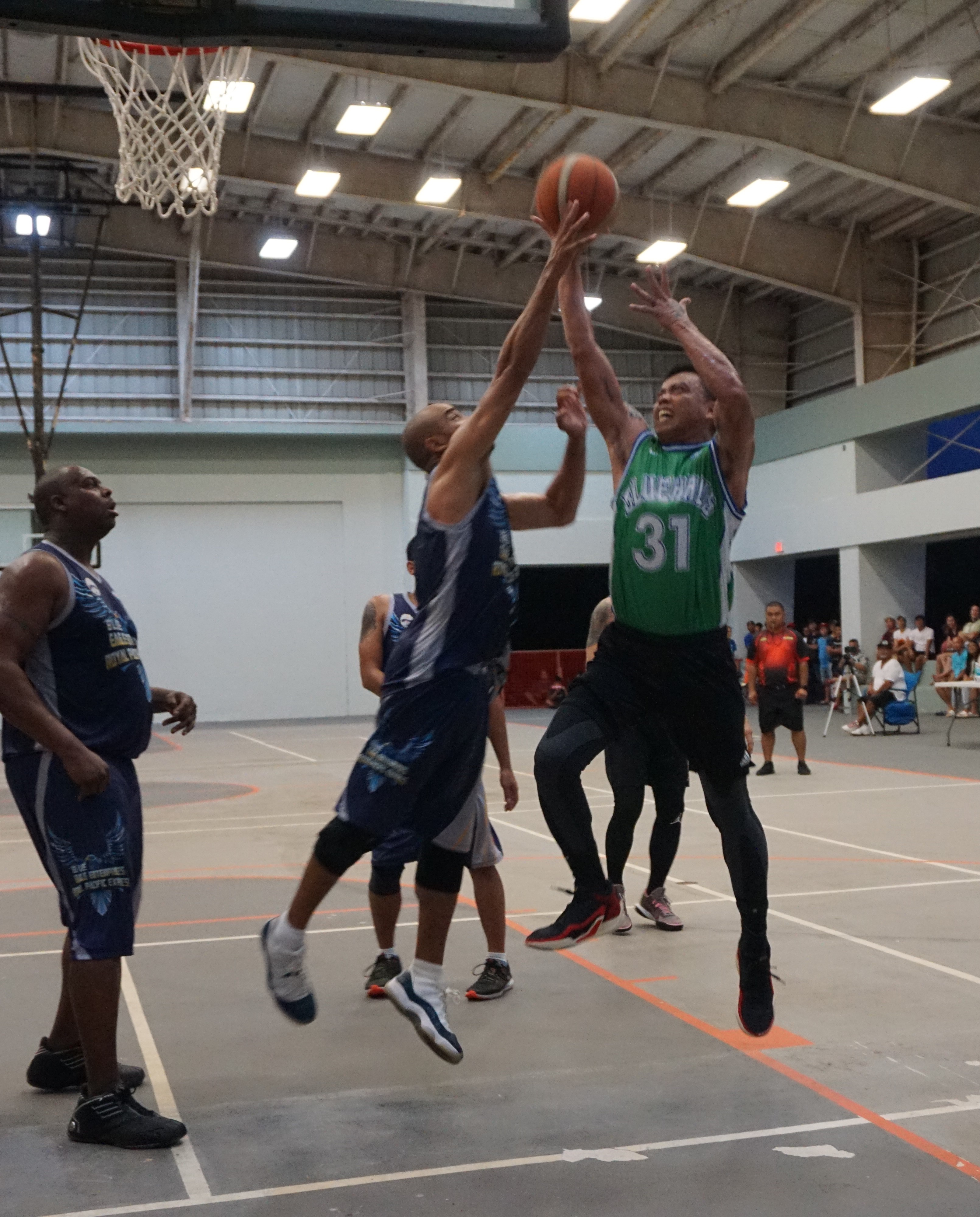 Blue Haus' Marlon De Dios gets fouled as he goes up for the shot during the masters division championship game  of the Saipan Centennial Lions Club Invitational Basketball League Tuesday at the Koblerville gym.