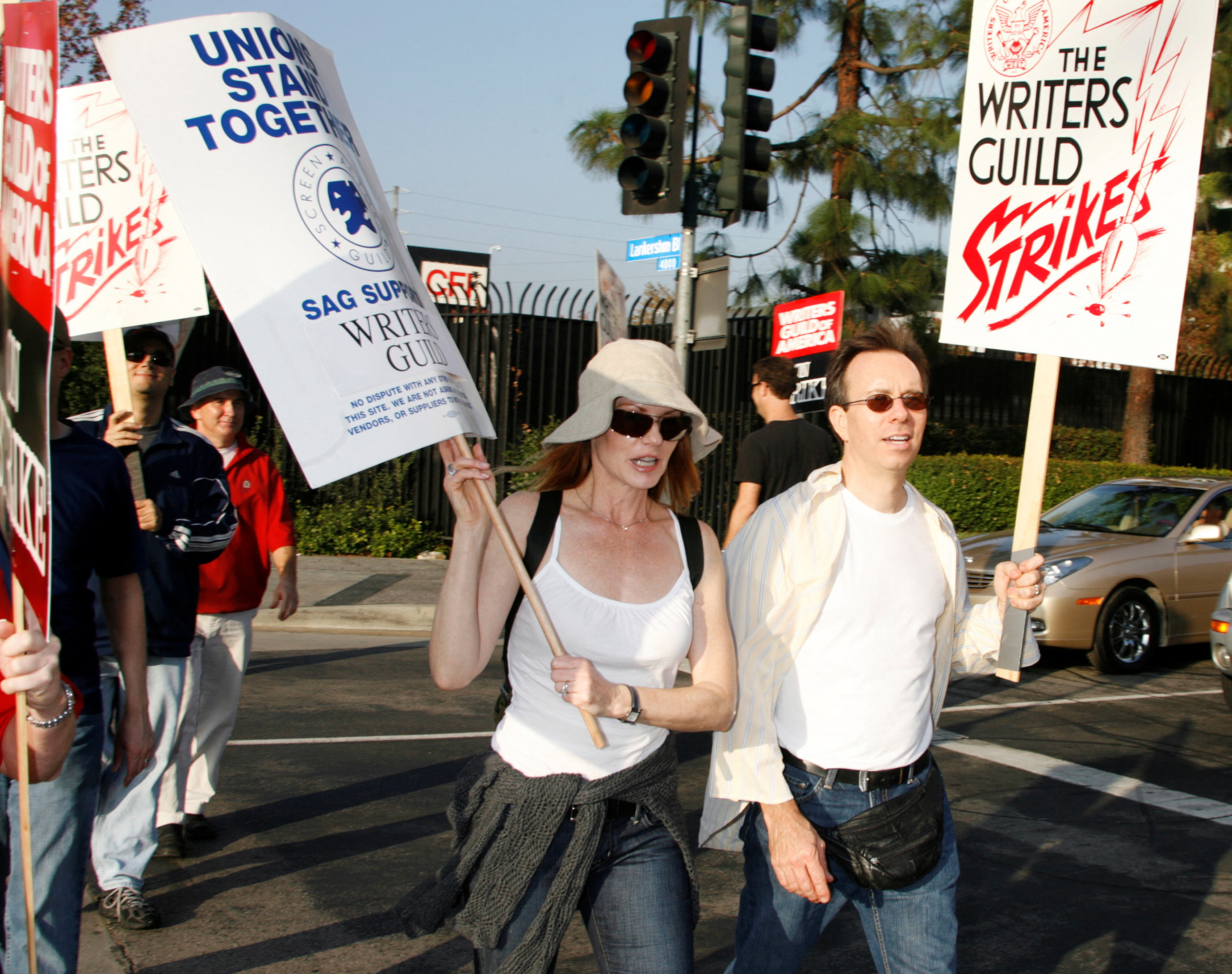 FILE PHOTO: Actress Marg Helgenberger (L), star of the CBS TV network series "CSI: Crime Scene Investigation" and a member of the Screen Actors Guild, walks a picket line along with members of the Writers Guild of America at one of the gates to Universal Studios in Los Angeles, California November 5, 2007. Some 12,000 screenwriters went on strike against the U.S. film and television industry on Monday after the collapse of last-ditch contract negotiations aimed at preserving nearly 20 years of Hollywood labor peace. REUTERS/Fred Prouser
