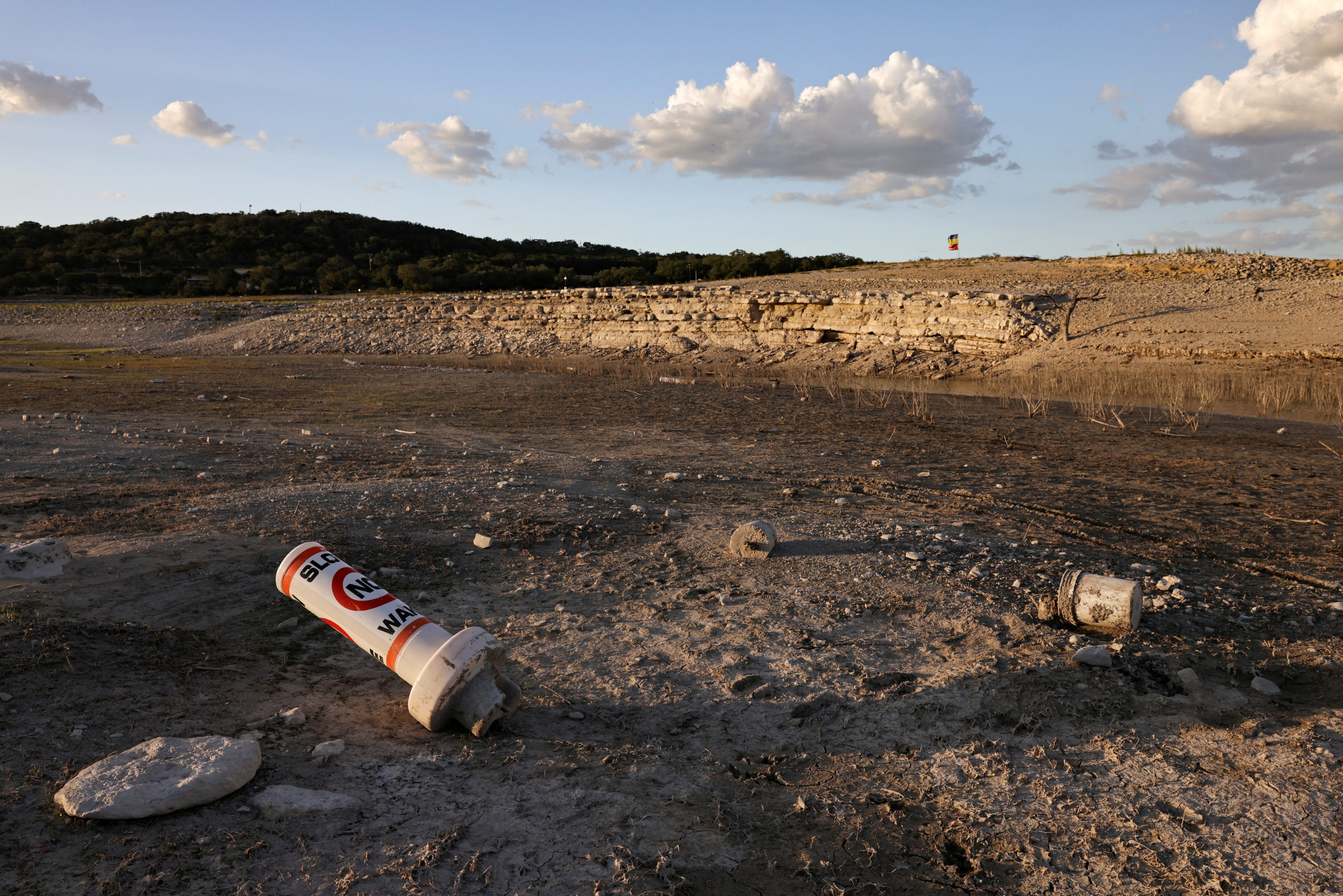 FILE PHOTO: A bouy normally used to mark "No wake" zones sits on dry land at Medina Lake outside of San Antonio as majority of Texas experiences drought amid an extreme heat wave hitting the state, in Medina County, Texas, U.S., June 18, 2022. REUTERS/Jordan Vonderhaar/File Photo