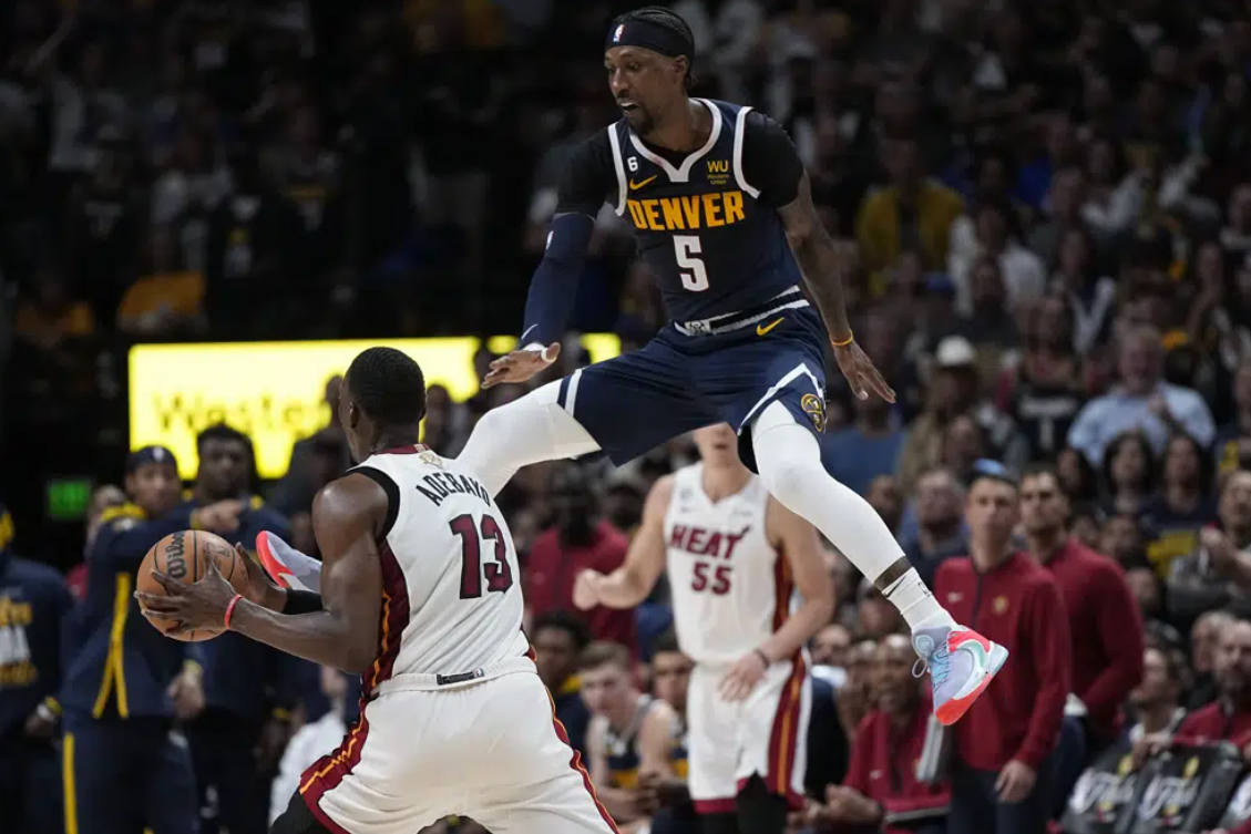 Miami Heat center Bam Adebayo (13) looks to pass while defended by Denver Nuggets guard Kentavious Caldwell-Pope (5) during the second half of Game 2 of basketball's NBA Finals, Sunday, June 4, 2023, in Denver.
