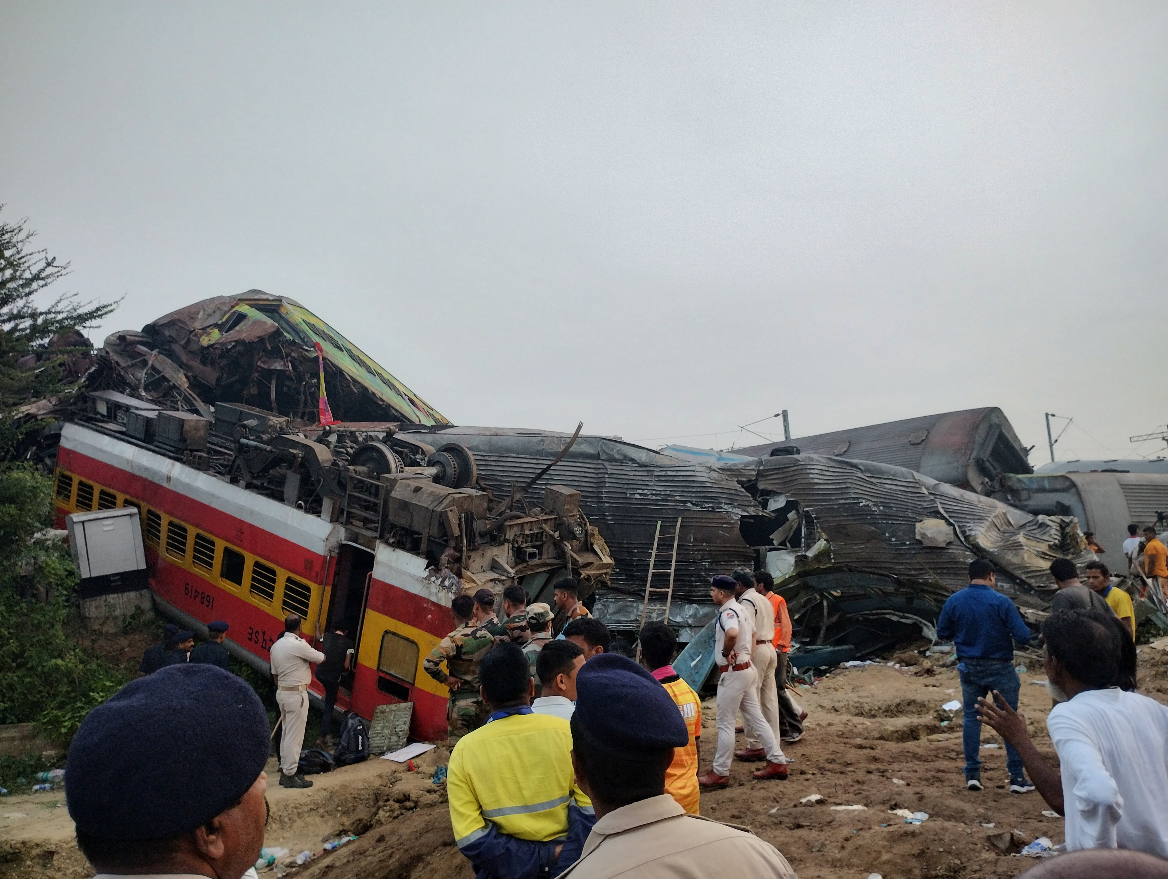 Onlookers and rescue workers stand next to damaged coaches, after trains collided in Balasore, India June 3, 2023, in this picture obtained from social media. Nantu Samui/via REUTERS