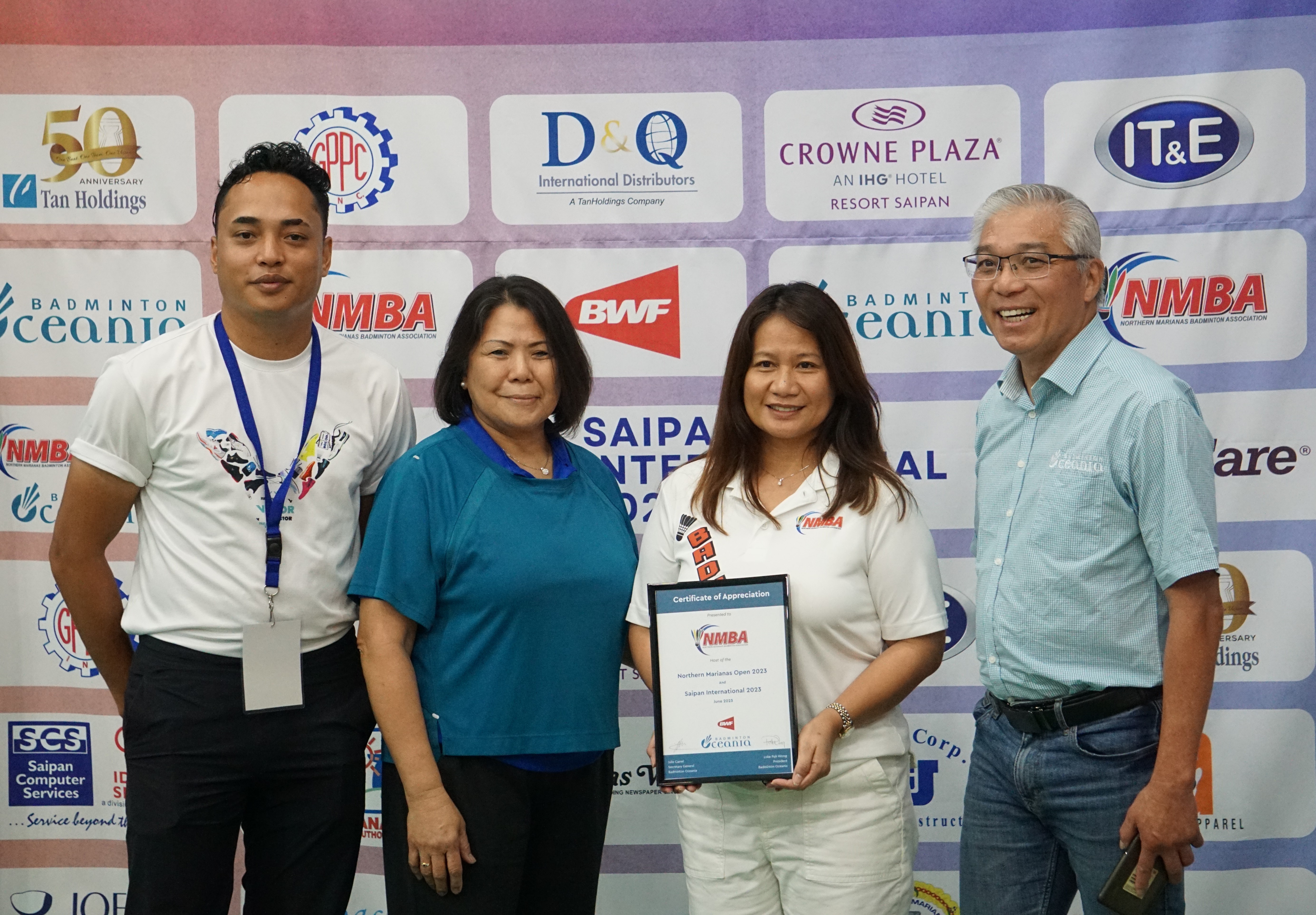 Northern Marianas Badminton Association President Merlie Tolentino, second right, holds the certificate of appreciation presented by Badminton Oceania President Loke Poh Wong, right,  during the awards ceremony of TakeCare Saipan International 2023 Sunday at the Ada gym.  Also in photo: NMBA Vice President Nate Guerrero and Treasurer Shirley Kim
