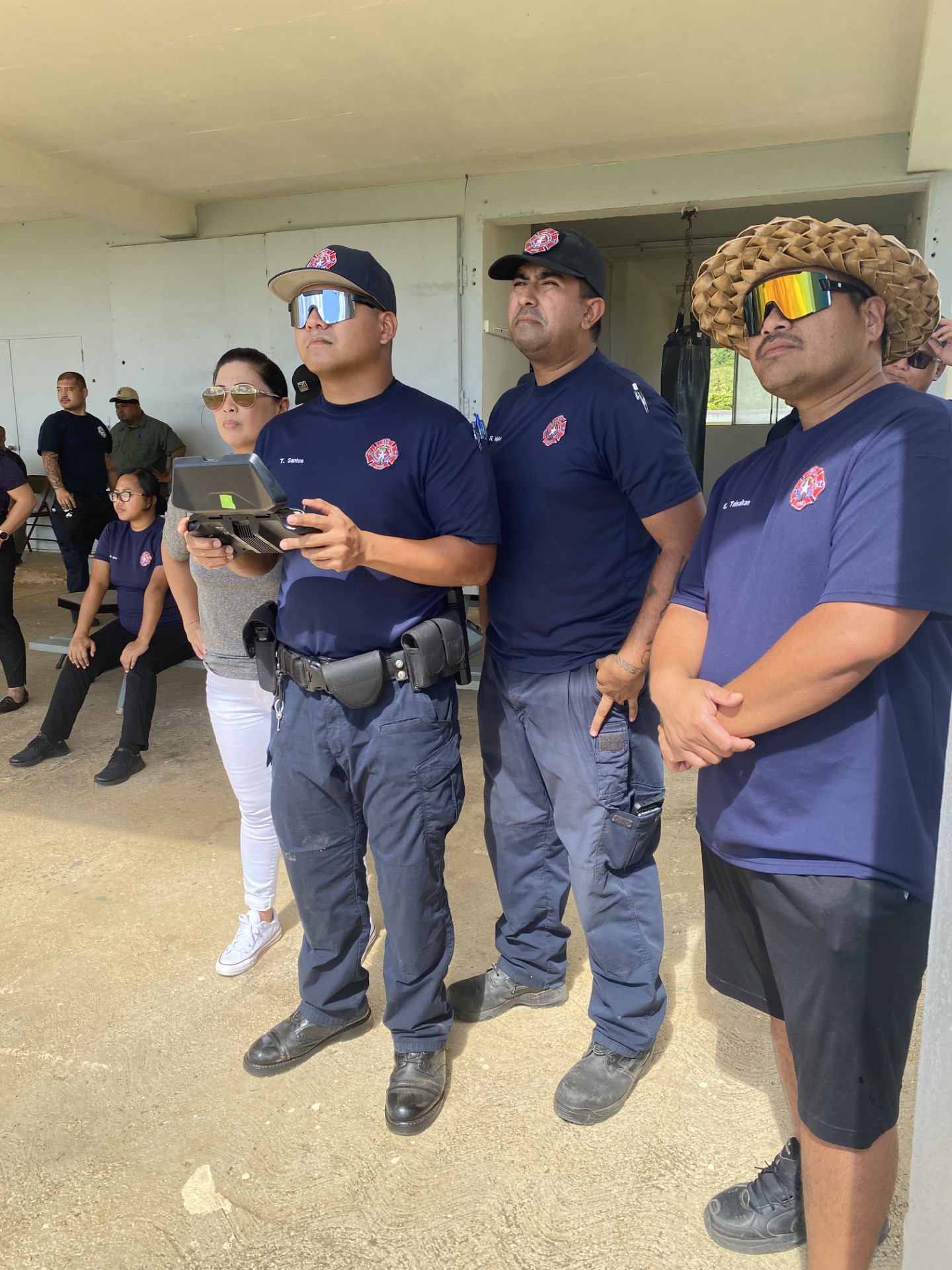 Tony Santos, left, stands next to Robert Mojica, center, at a training event lead by Bella Wings Aviation on June 21.
