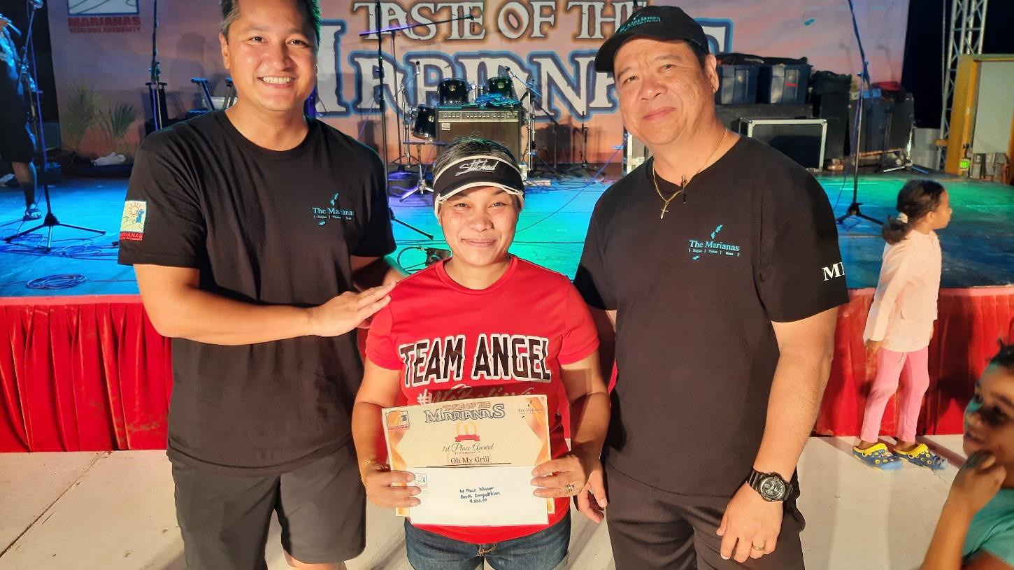 On behalf of OMG – Oh My Grill, Karen Kalen, center, receives 1st place on June 24, 2023, in the booth decorating contest at the 24th Annual Taste of the Marianas International Food Festival & Beer Garden, at Garapan  Fishing Base in Saipan.  From left, Marianas Visitors Authority Managing Director Christopher A. Concepcion, Kalen, and MVA Community Projects Manager Martin Duenas.  The food festival is an annual signature event of MVA.