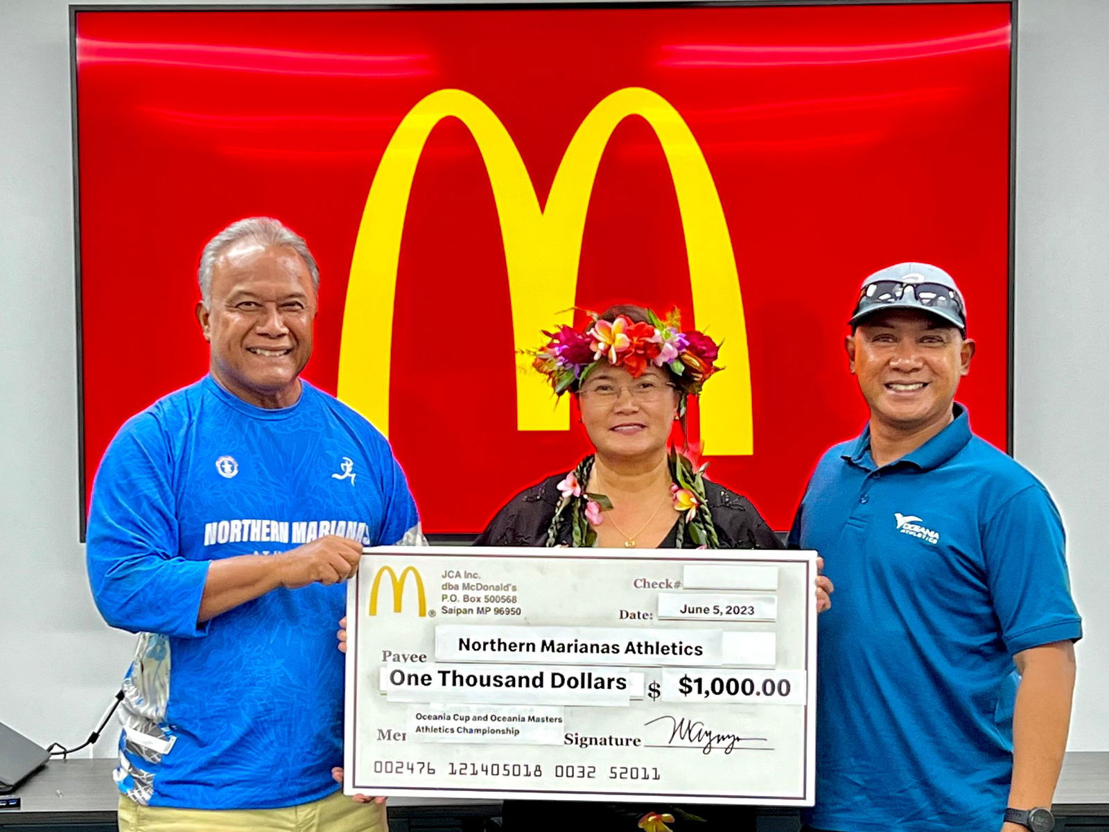 Oceania Athletics local organizing committee’s Robin Sapong, right, and Ramon Tebuteb, left, with Marcia Erra Ayuyu, vice president and owner/operator of McDonald’s Guam and Saipan.