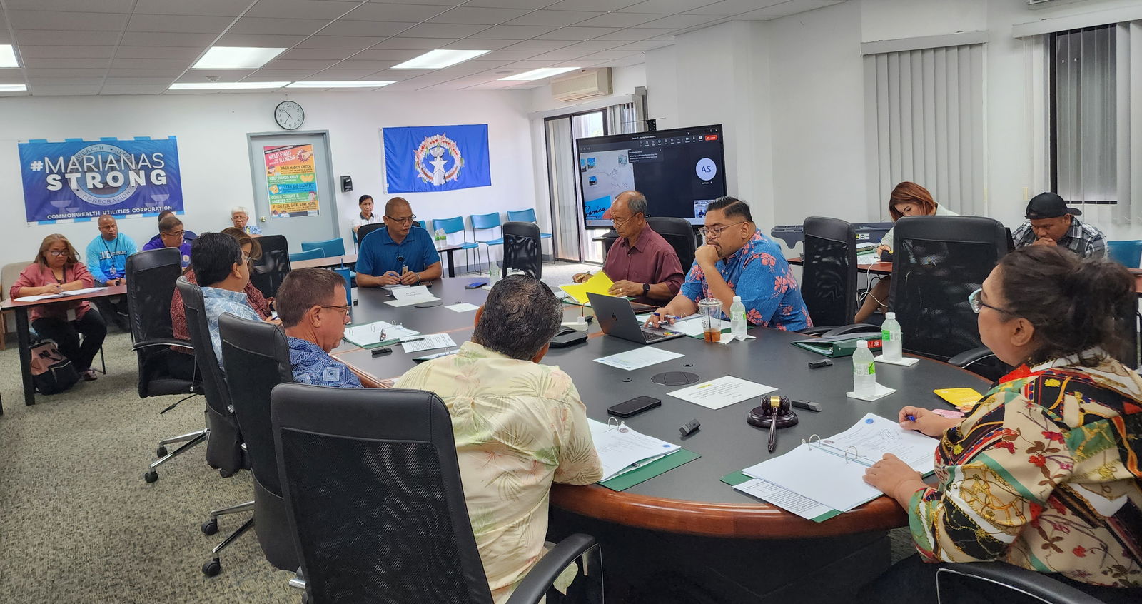 Rep. Vince Seman Alda, center background, speaks during the Commonwealth Utilities Corp. board meeting on Friday.