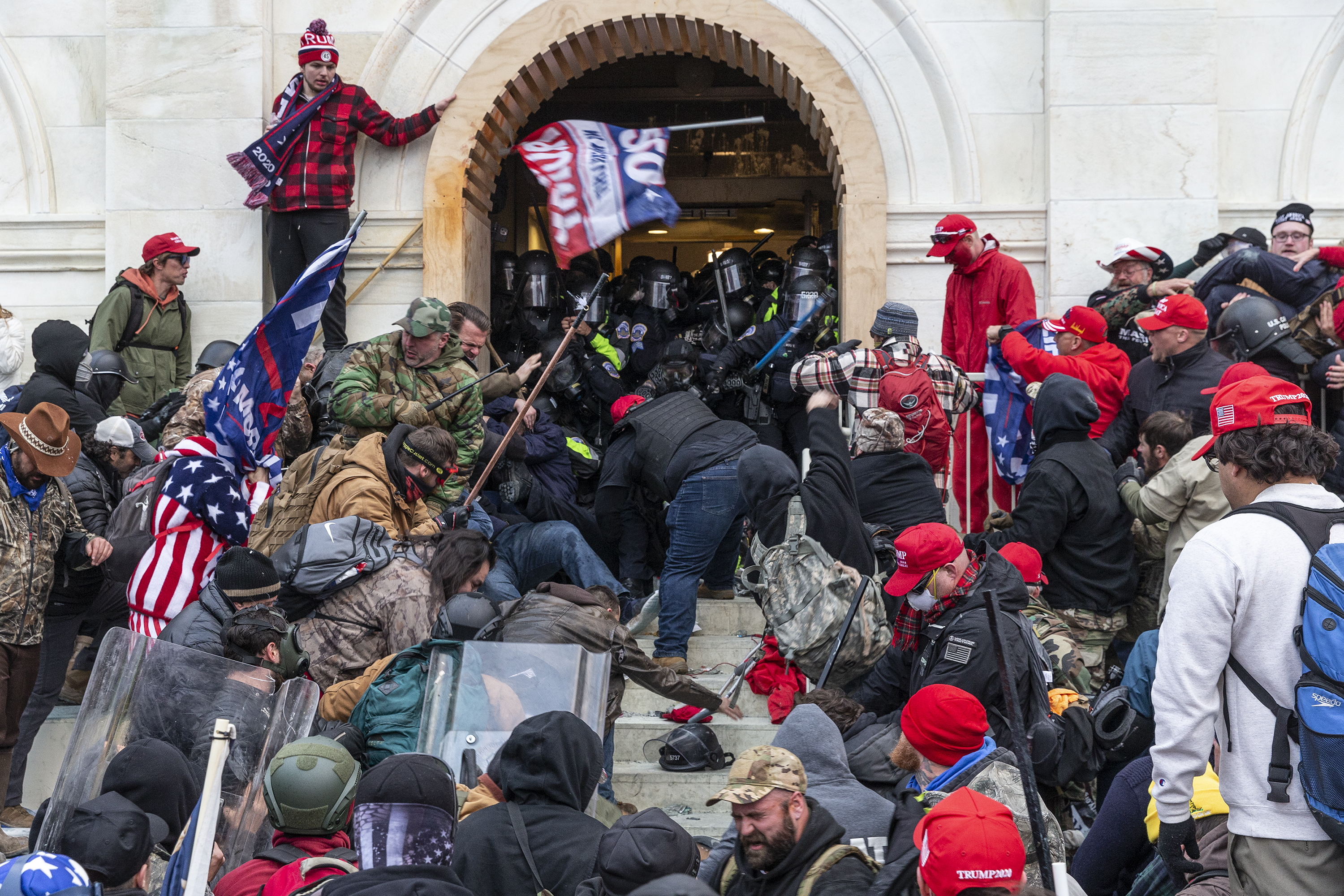 Rioters clash with police trying to enter Capitol building through the front doors. Rioters broke windows and breached the Capitol building in an attempt to overthrow the results of the 2020 election. Rioters used metal bars and tear gas as well against the police. (Lev Radin/Pacific Press via Zuma Press Wire/TNS)