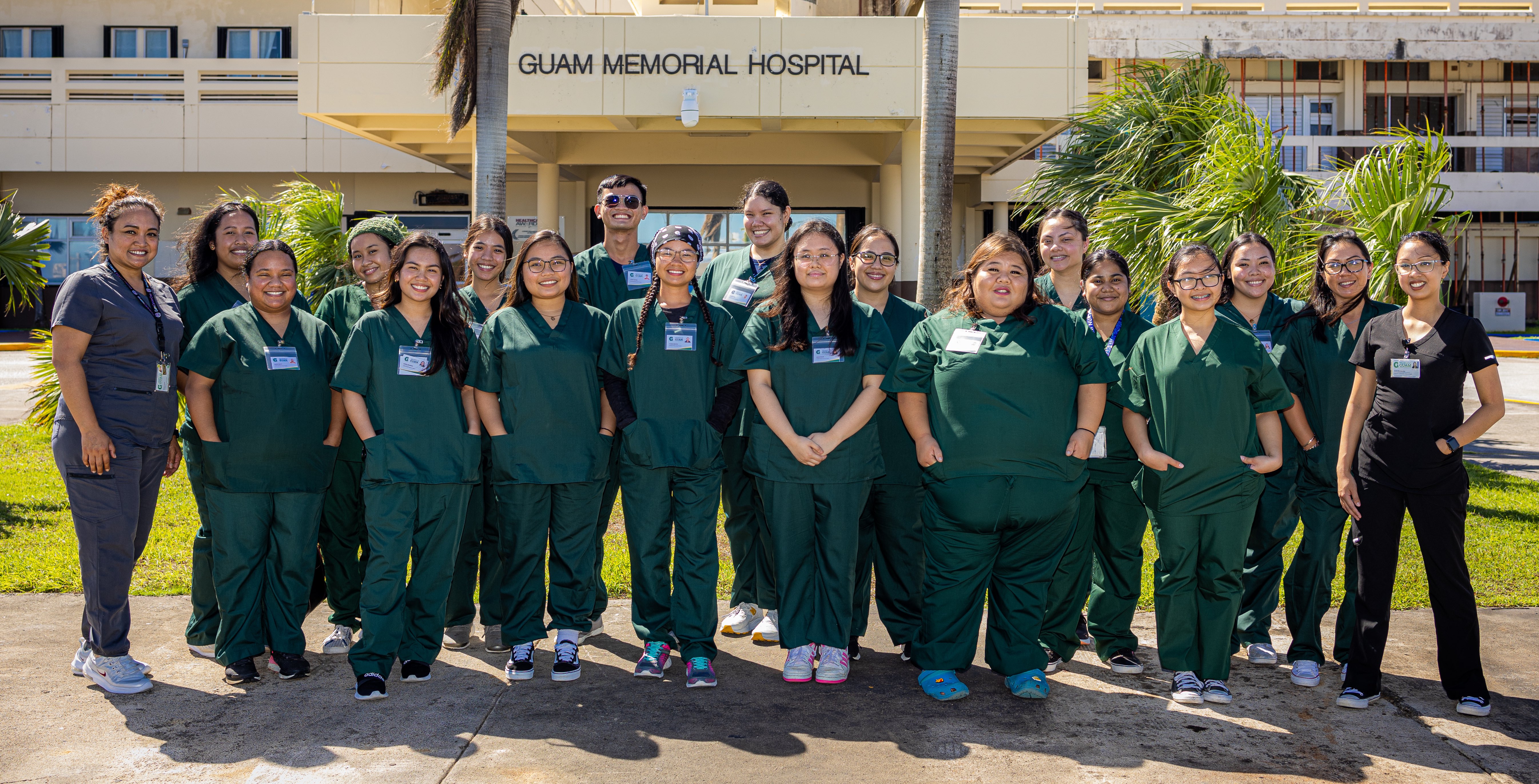 Marissa Anderson, Clinical Nurse Practitioner and Educator with the University of Guam Certified Nursing Assistant program, first from left, and Jen Salas, who assists Anderson with the program, first from right, are seen with the CNA students outside Guam Memorial Hospital on June 14, 2023. The students are seen in green scrubs, from left, front row: Kaylah Roduk; Arniela Dimabuyu; Kyla Mercado; Yvanna Guzman; Jerene Donato; Samara Cruz; and Nicole Mejia. From left, back row: Brittney Aichem; Hannah Maxino; Tiana Damon; Vince Verango; Jennifer Wiley; Kimberly Besabe; Jessalynn Chiguina; Amy Robert; Ha'ane Wright; and Jomayne Guzman.