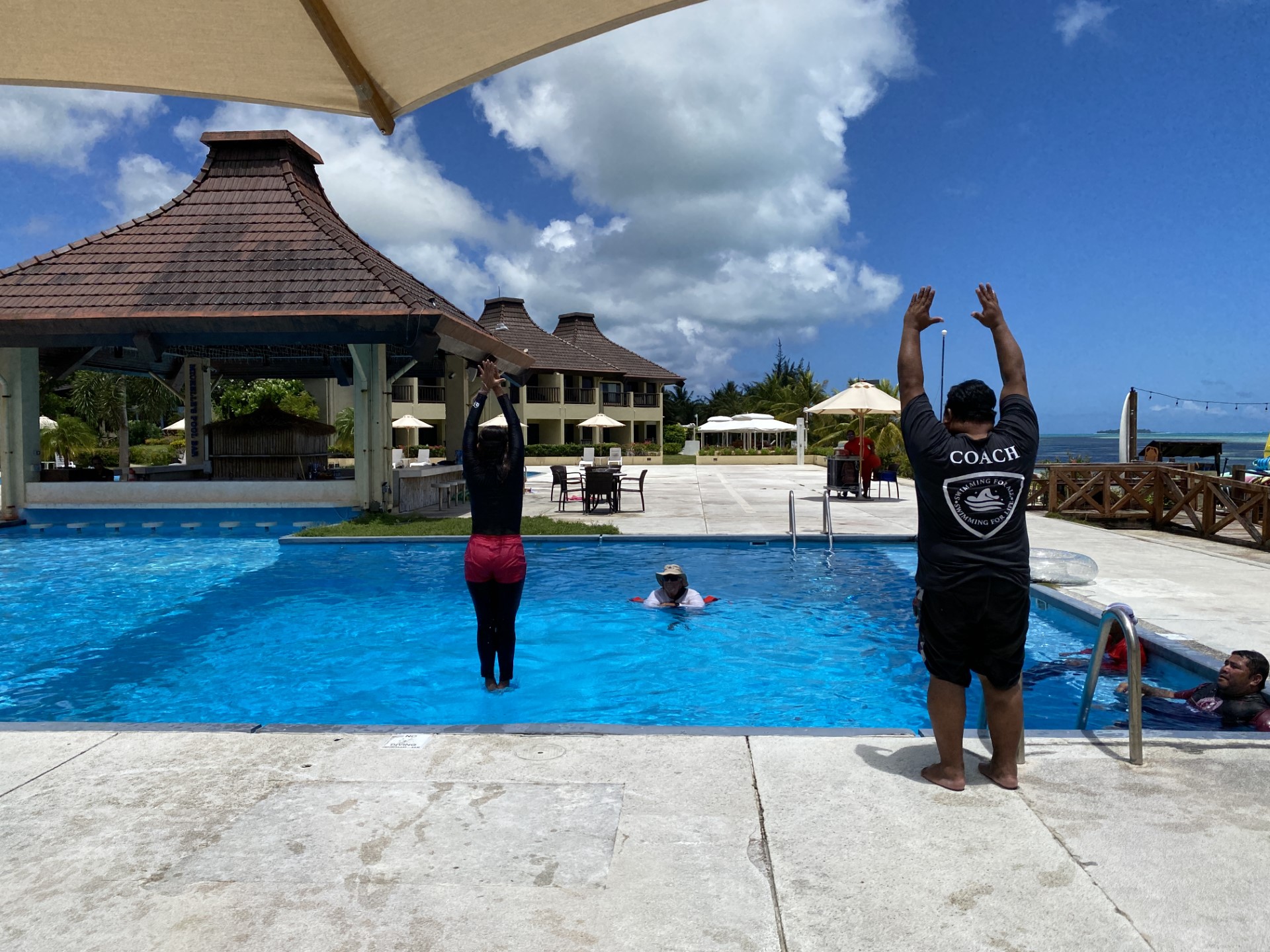 Alisa Baquilles, left, jumps into the water as part of a simulated lesson led by Joe Etpison.