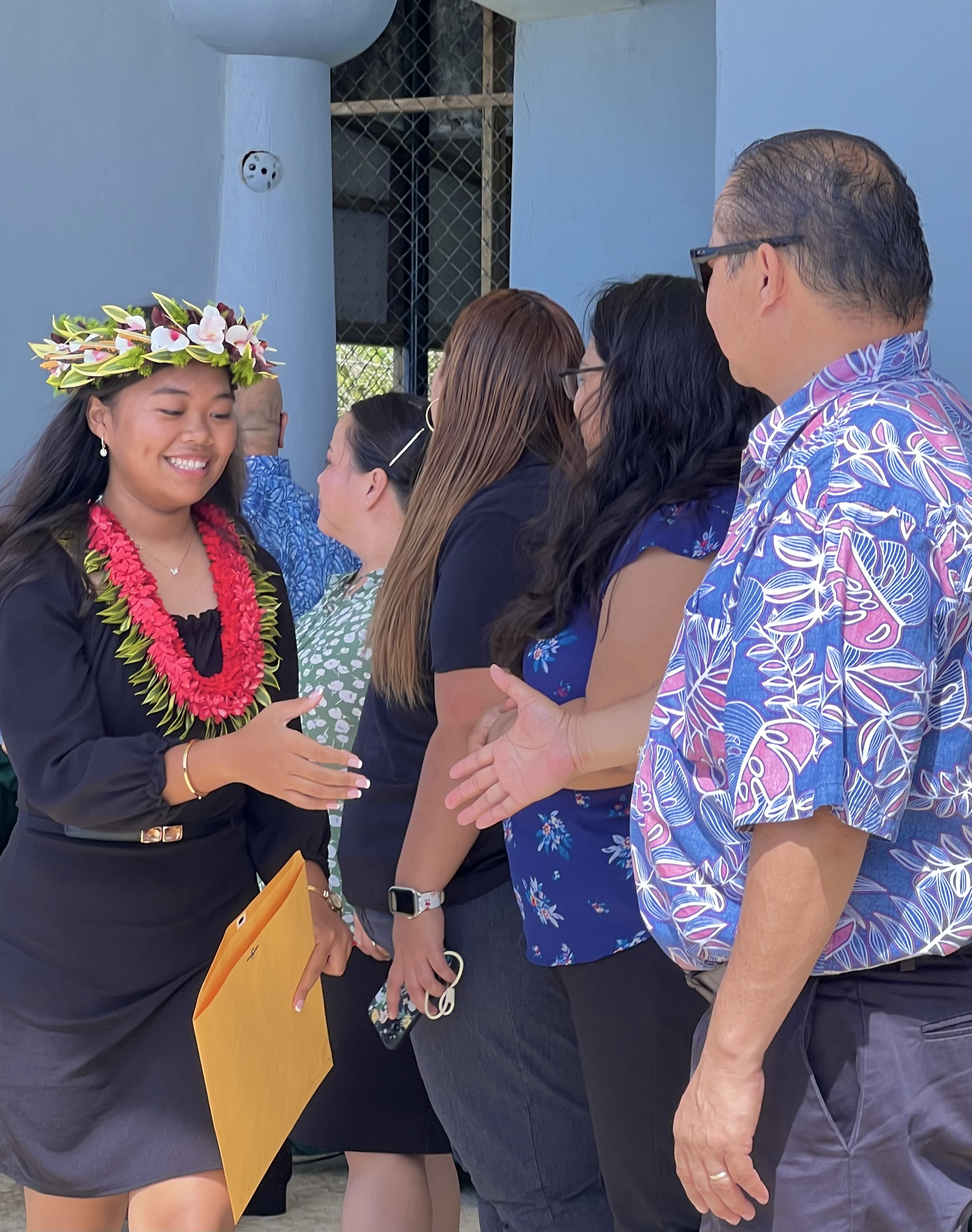 Newly promoted Dandan Middle School student Lian Brien is congratulated by Commissioner of Education Dr. Alfred B. Ada.