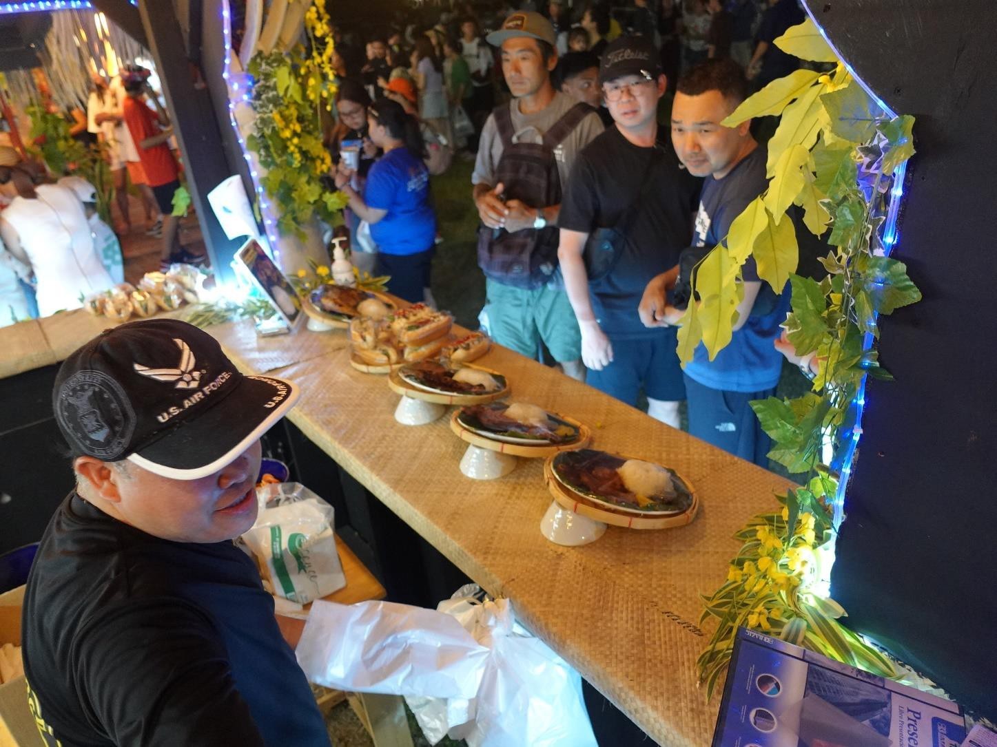 Dante Conlu of Saipan Cup Bap, left, serves patrons at the 24th  Annual Taste of the Marianas International Food Festival & Beer Garden on June 17, 2023, at Garapan Fishing Base, Saipan.  The festival is an annual signature event of the Marianas Visitors Authority and features food, drinks, live entertainment, and arts and crafts.