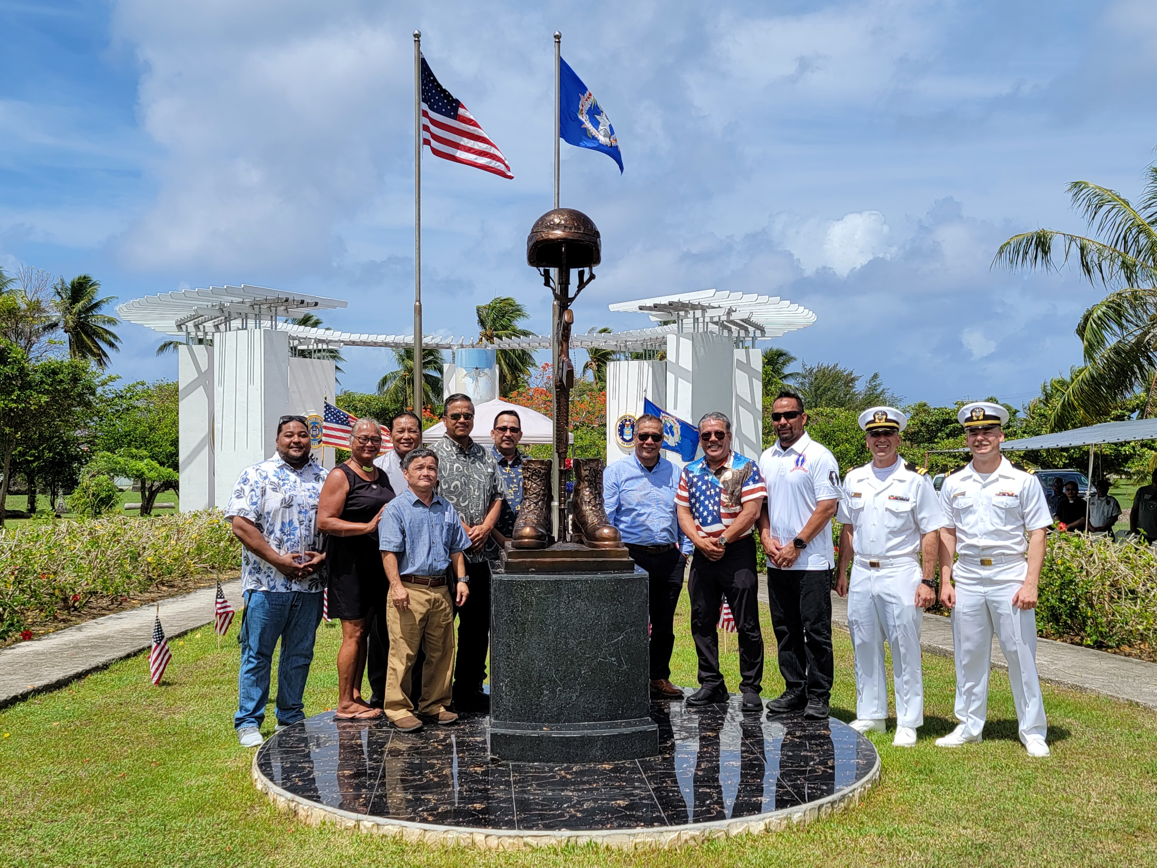 Tinian Mayor Edwin P. Aldan, fourth right, and other members of the Tinian leadership, pose for a photo with Naval Mobile Construction Battalion Five's Lt. Joseph Plunkett, second right, Lt. Anthony M. Anason, right and Commonwealth Bureau of Military Affairs Special Assistant Danny Aquino after the unveiling of the Fallen Soldier Memorial Monument on Tinian, Monday last week.