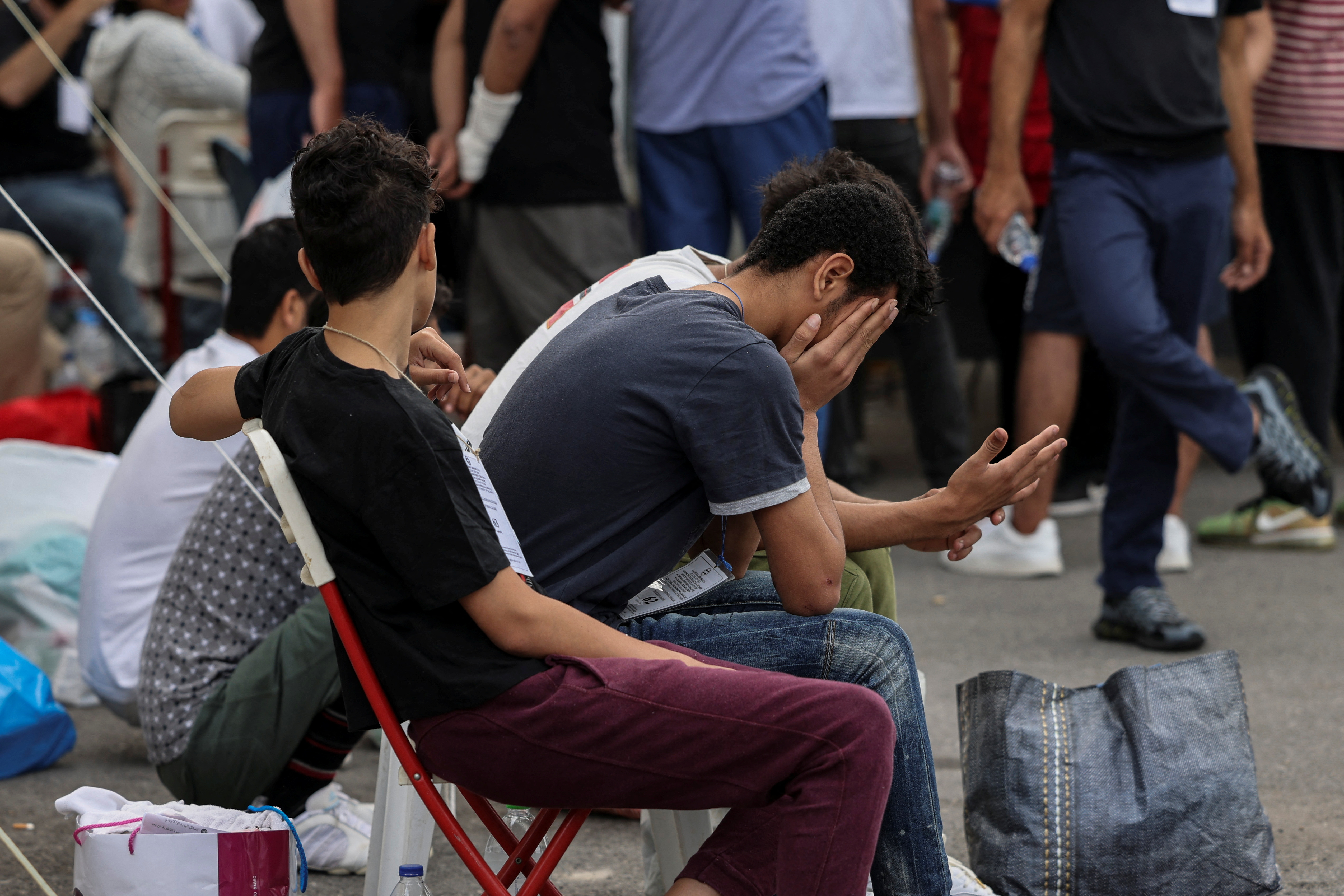 Migrants, survivors of a deadly shipwreck after a boat capsized at open sea off Greece, wait to board a bus as they are being transferred to Athens from the port of Kalamata, Greece, June 16, 2023. REUTERS/Stelios Misinas