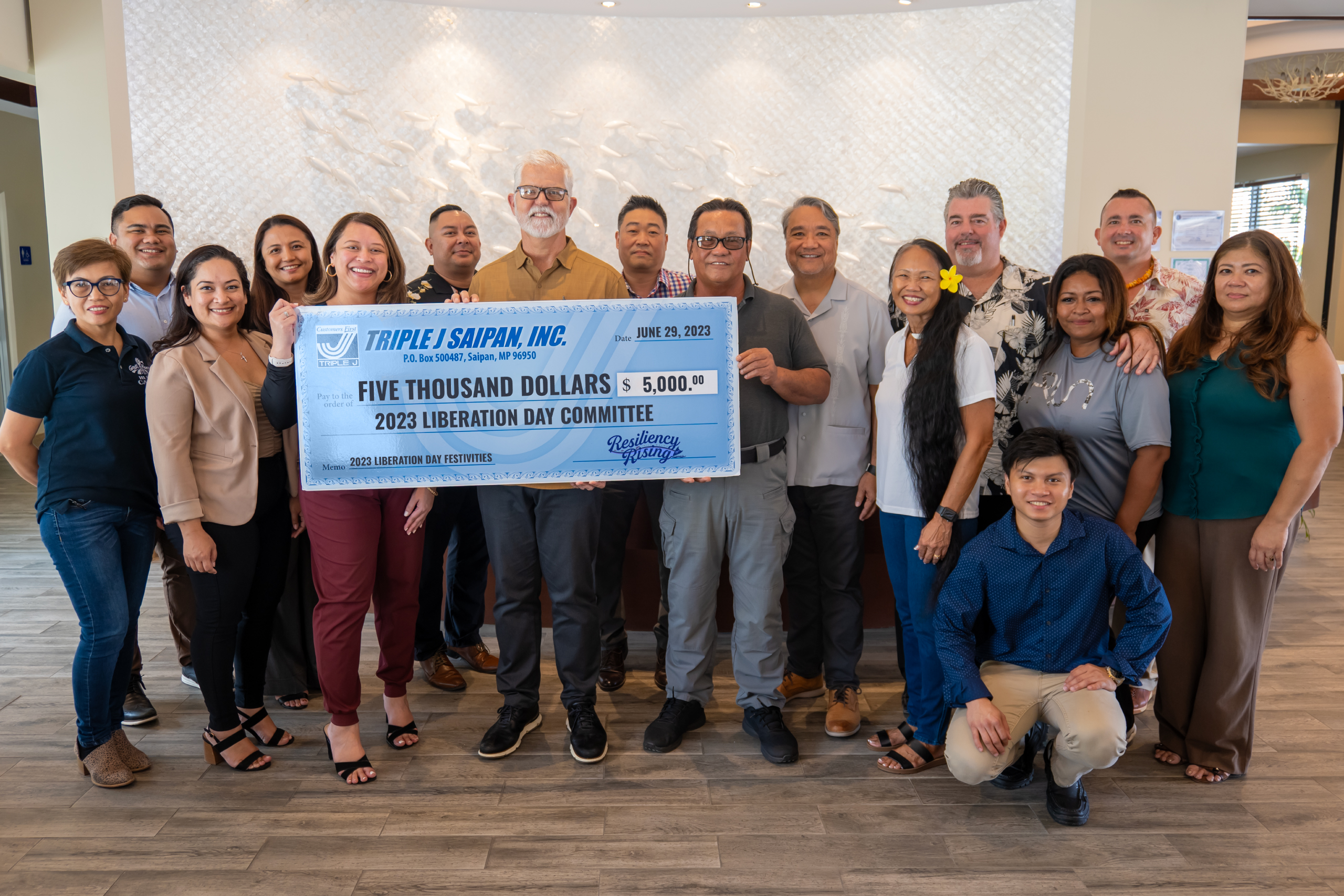 Back row, from left, Jose Mafnas, Triple J corporate counsel; Kina Peter, TJ corporate comptroller; Fred Camacho, TJ business development manager; Keith Ahn, Surf Rider hotel general manager; Frank Ada, TJ human resources director; Mario Valentino, TJ construction operations manager; Brad Ruszala, TJ CNMI marketing manager. Front row, from left, Carol Lucenara, Great Harvest general manager; Natashia Tomokane, Saipan Mayor's Office; Nadine Deleon Guerrero, Liberation Day Committee chair; Jeffrey Jones (Triple J president and chief operating officer; Ramon B. Camacho, mayor of Saipan; Frances Sablan, Liberation Day Committee; Joy Maratita, Liberation Day Committee; Rachel Roque, TJ real estate manager. Kneeling: Paul Manicad, Surf Club restaurant manager.