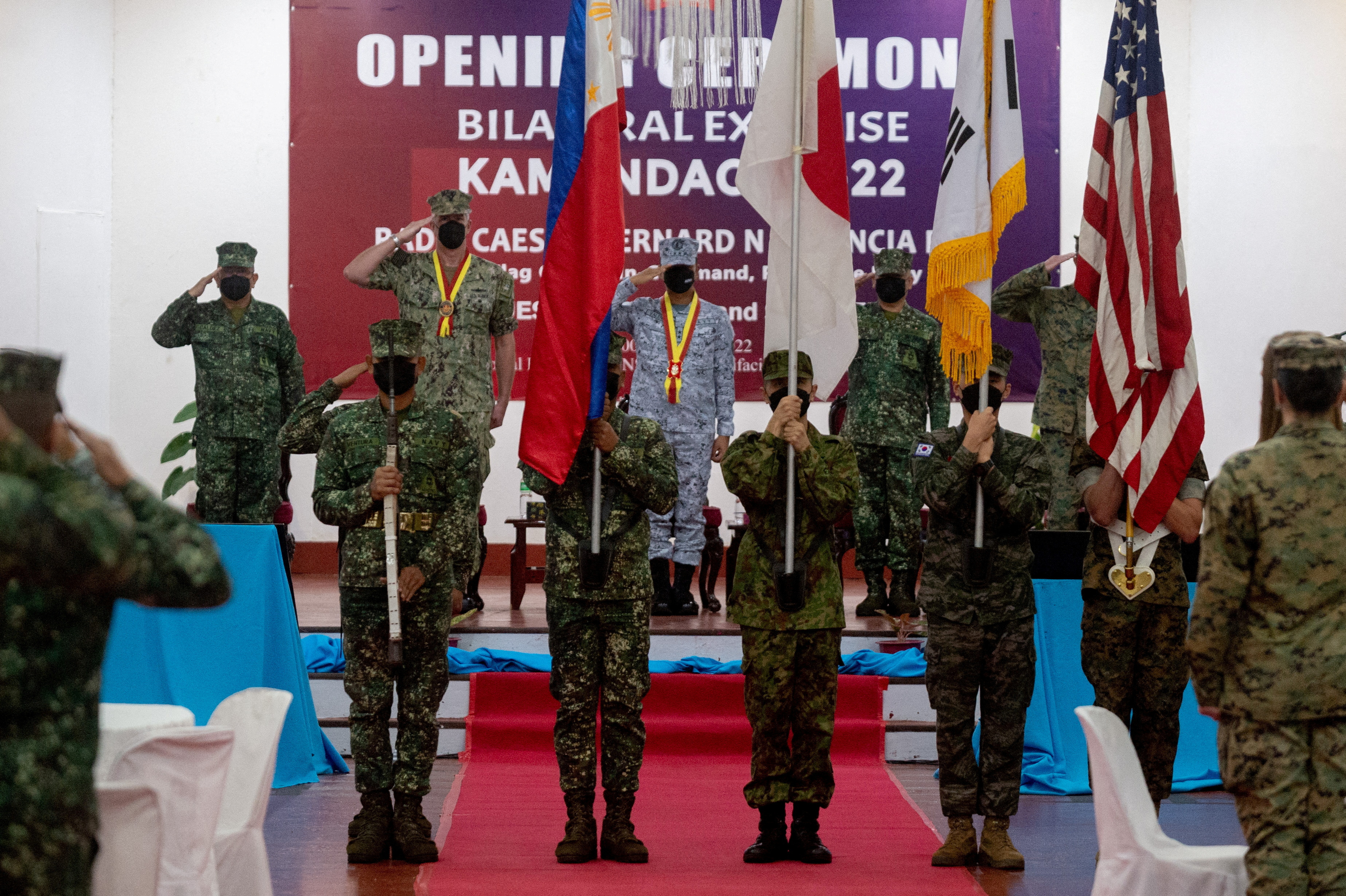 FILE PHOTO: Members of the Philippine, Japan, South Korea, and U.S. Marines carry national flags during the opening ceremony of the joint military exercises Kamandag or the “Cooperation of the Warriors of the Sea,” at the headquarters of Philippine Marine Corps, in Taguig City, Metro Manila, Philippines, October 3, 2022. REUTERS/Lisa Marie David/File Photo