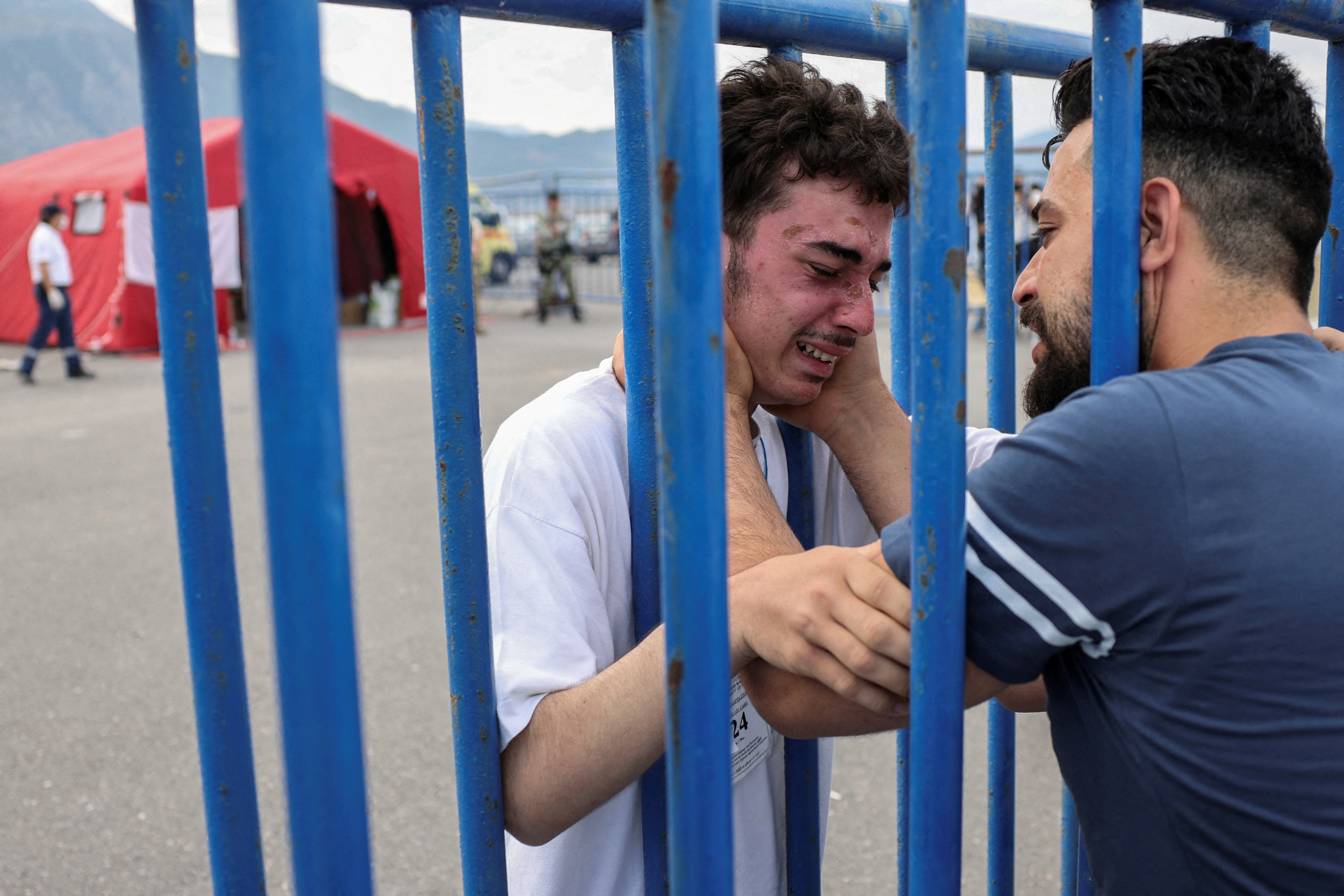 Syrian survivor Fedi, 18, who was rescued with other refugees and migrants at open sea off Greece after their boat capsized, cries as he reunites with his brother Mohammad, who came to meet him from Italy, at the port of Kalamata, Greece, June 16, 2023. REUTERS/Stelios Misinas