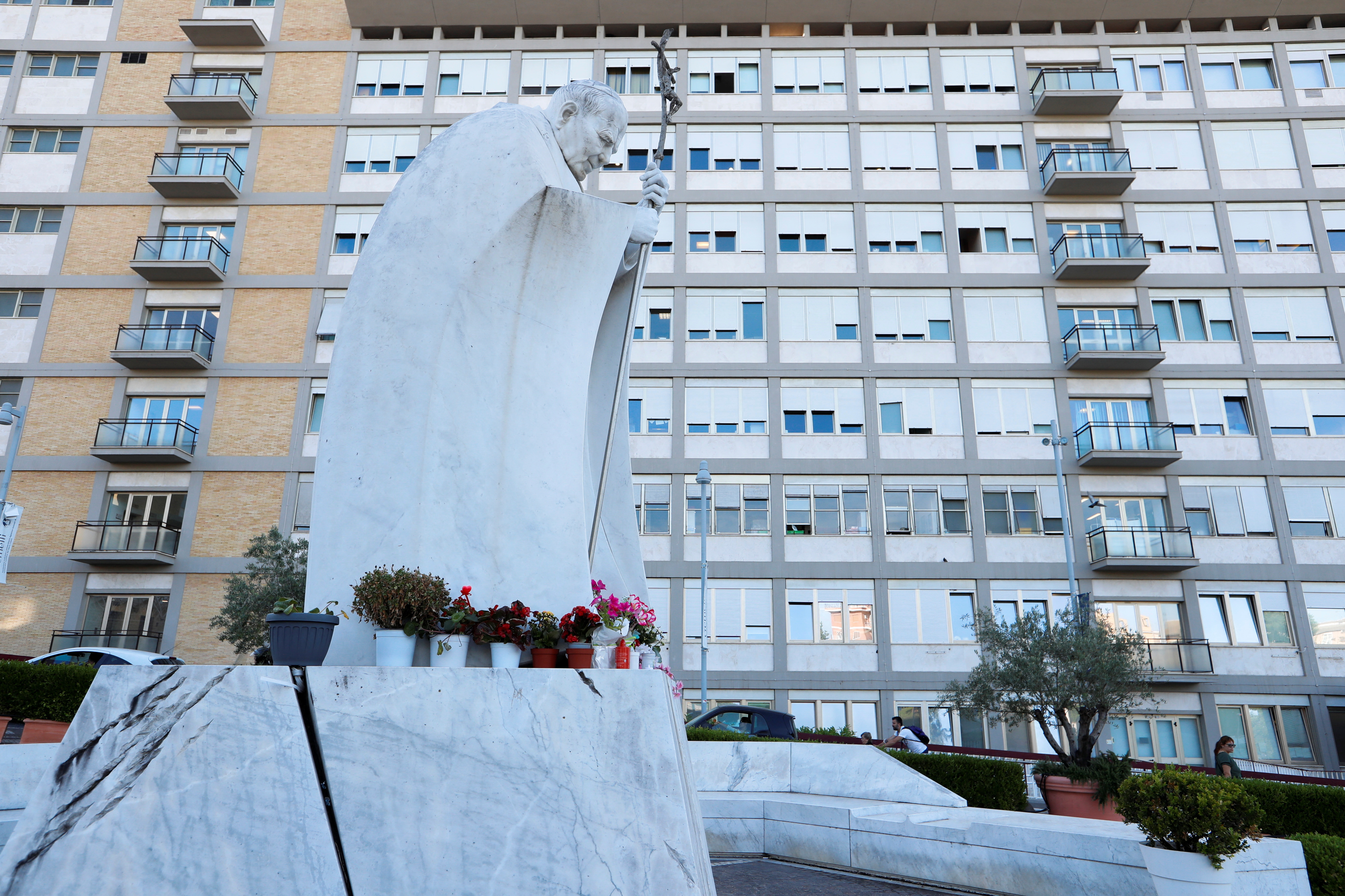 Flowers are seen at the statue of Pope John Paul II at Gemelli Hospital where Pope Francis is hospitalised for surgery on his abdomen, in Rome, Italy, June 9, 2023. REUTERS/Remo Casilli