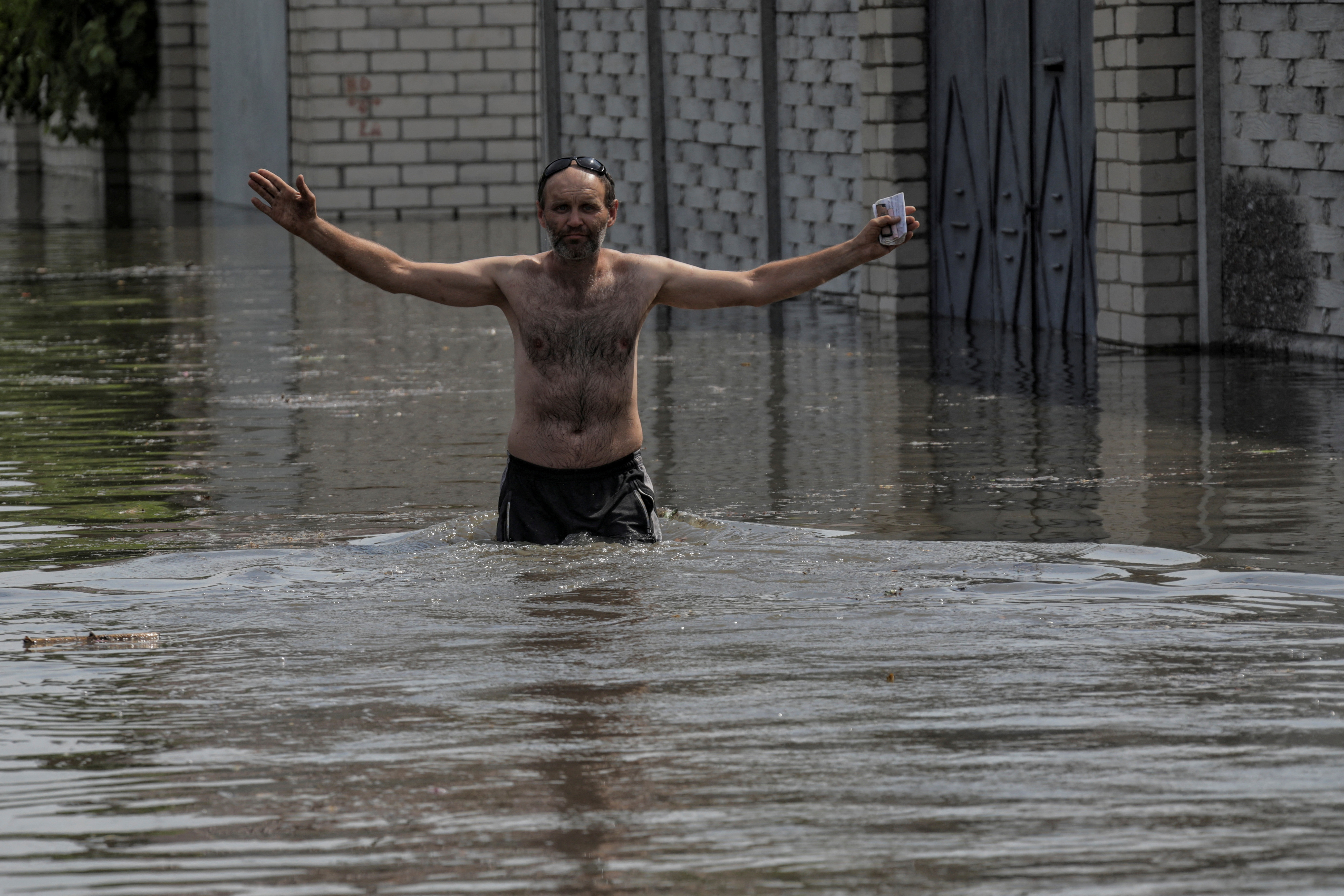 A local resident walks on a flooded street after the Nova Kakhovka dam breached, amid Russia's attack on Ukraine, in Kherson, Ukraine June 6, 2023. REUTERS/Stringer