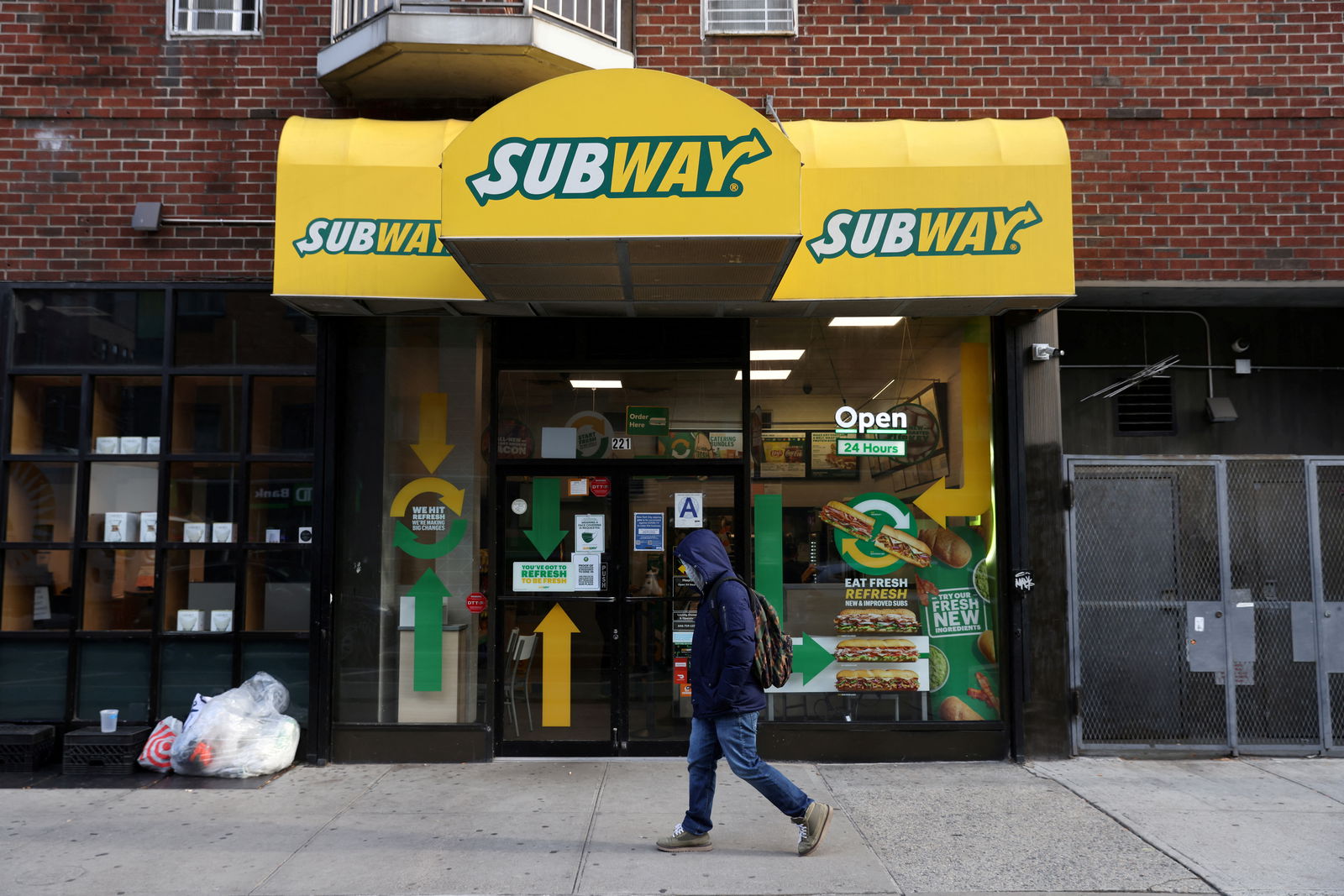 FILE PHOTO: A person walks by a Subway restaurant in Manhattan, New York City, U.S., November 23, 2021. REUTERS/Andrew Kelly/File Photo