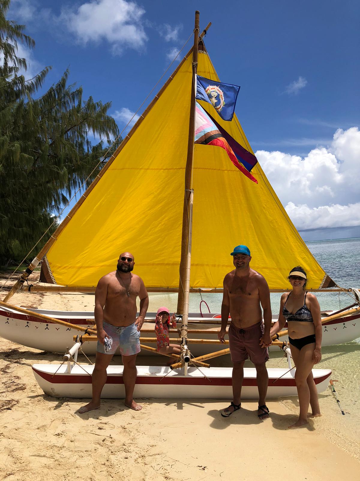 Event organizer Roberto Santos stands in front of 500 Sails canoe Aunty Oba with his niece Victoria Santos, his brother Carlos Santos and sister-in-law Raquel Santos.