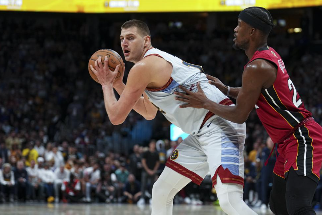Denver Nuggets center Nikola Jokic, left, is defended by Miami Heat forward Jimmy Butler, right, during the second half of Game 5 of basketball's NBA Finals, Monday, June 12, 2023, in Denver.