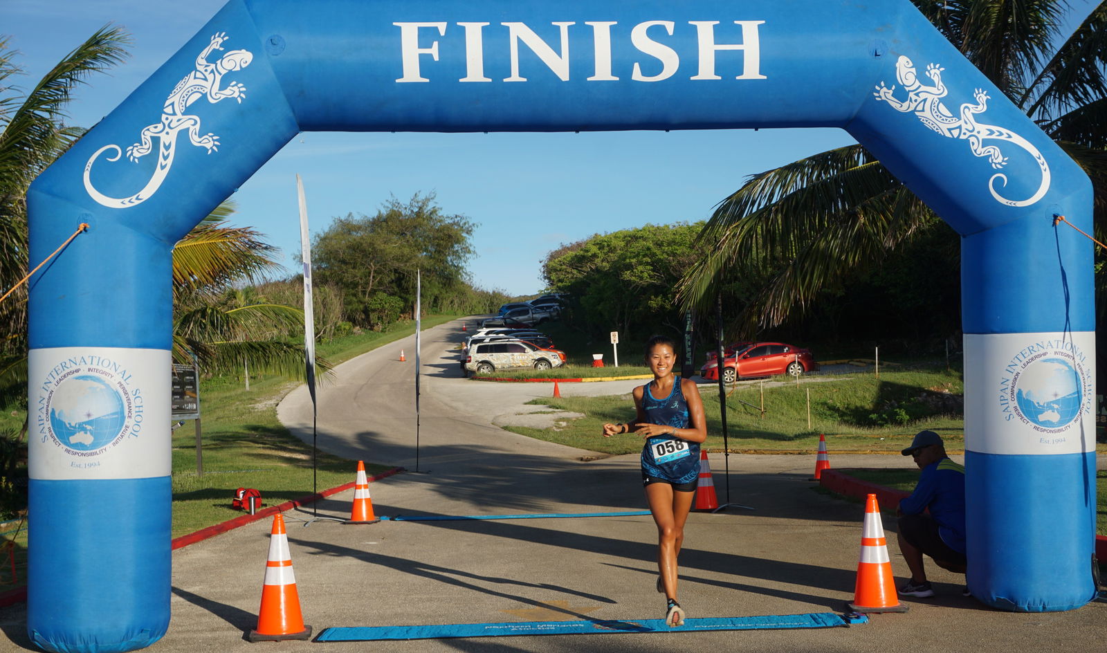 Tania Tan smiles as she crosses the finish line of the 2nd Run Saipan Grotto 10K3 Saturday at the Grotto.