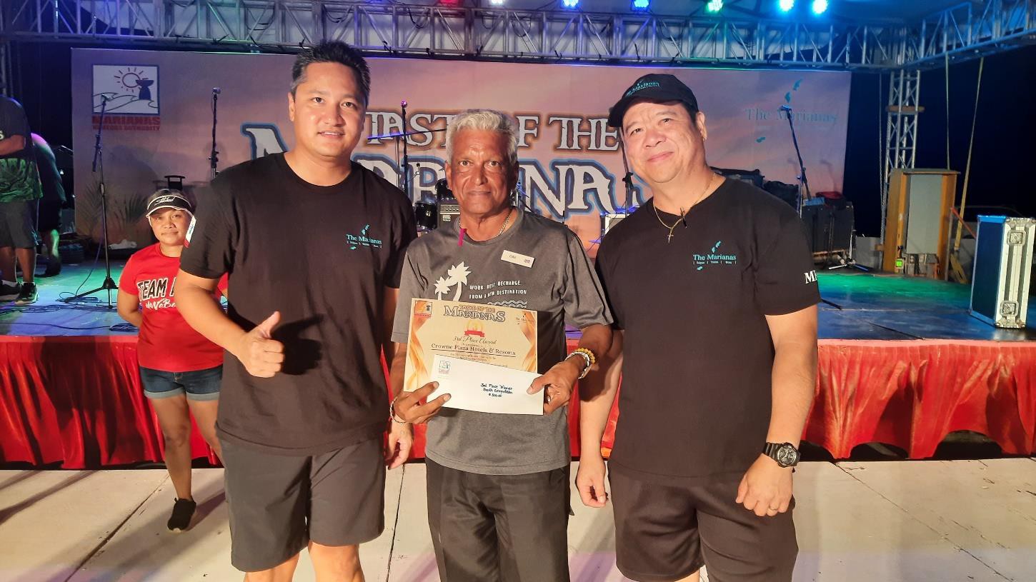 On behalf of Crowne Plaza Resort Saipan, Banquets & Events Director Das Krishnan, center, receives 3rd place on June 24, 2023, in the booth decorating contest at the 24th Annual Taste of the Marianas International Food Festival & Beer Garden, at Garapan Fishing Base in Saipan.  From left, Marianas Visitors Authority Managing Director Christopher A. Concepcion, Krishnan, and MVA Community Projects Manager Martin Duenas. 