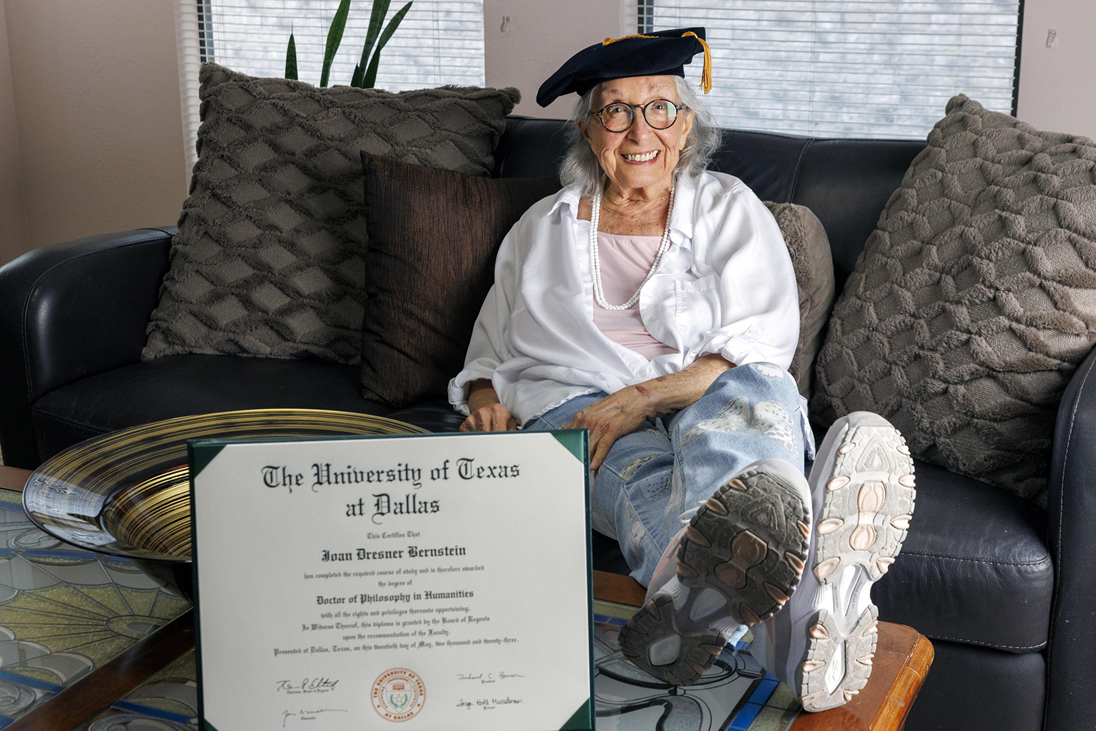 Joan Bernstein, 88, wears her tam from her doctoral hooding ceremony alongside her doctor of philosophy in humanities diploma at her home in Garland, Texas, Wednesday, May 31, 2023. Bernstein is the the oldest person ever to earn a doctoral degree at the University of Texas at Dallas. (ElÃ­as Valverde II/Dallas Morning News/TNS)