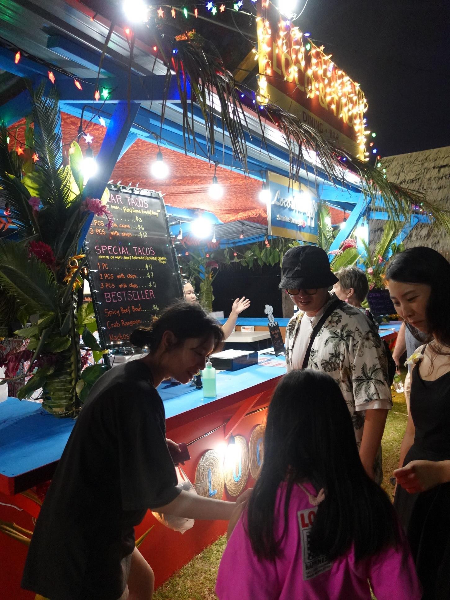 Visitors to the Marianas check out the menu at Loca & Taco at the 24th Annual Taste of the Marianas International Food Festival & Beer Garden on June 3, 2023, in Saipan.