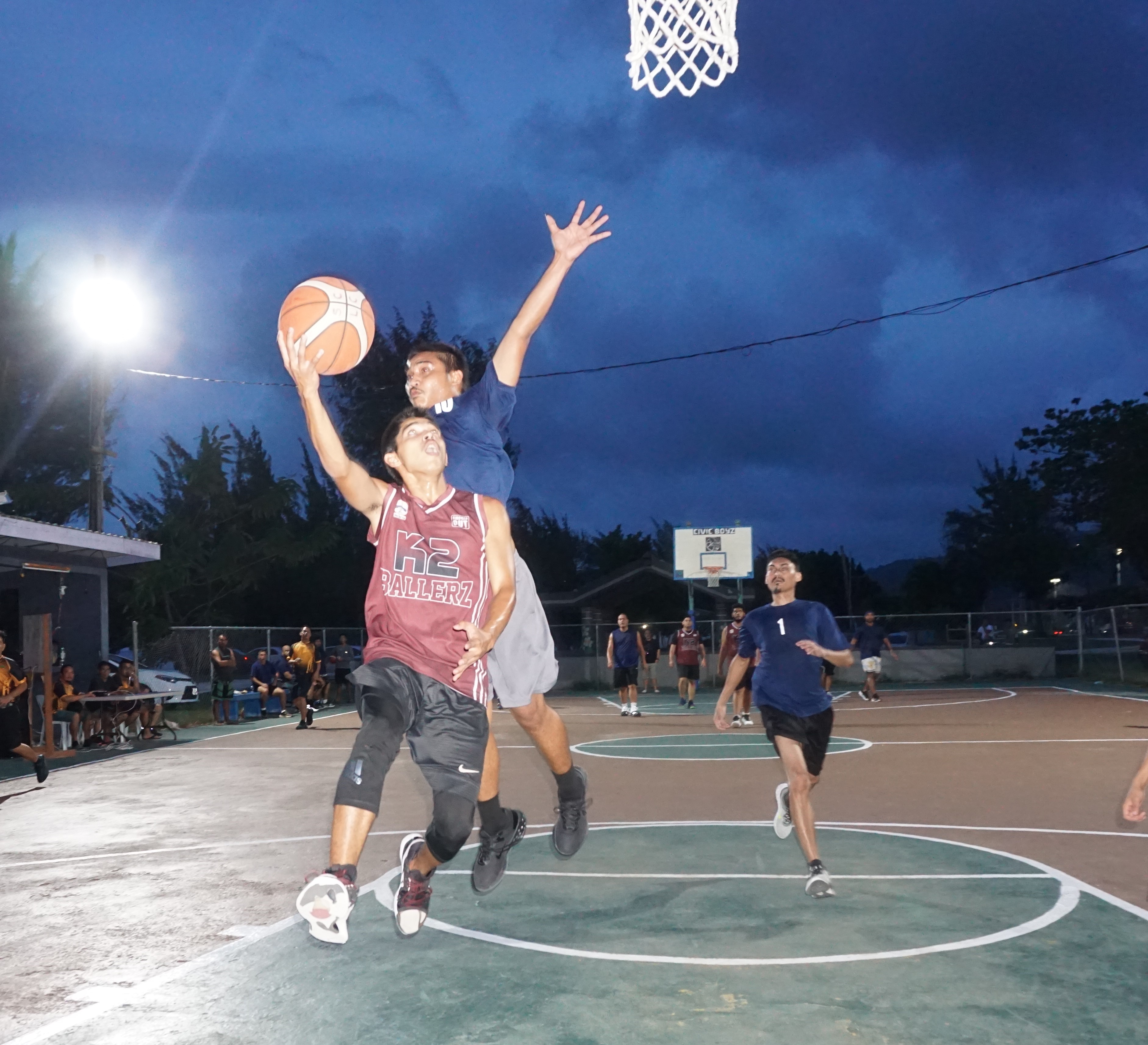K2 Ballerz's Jerald Mamis extends for the finish as Martech Ol'Aces' Kevin Kabiriel attempts the chase down block during  a Saipan Centennial Lions Club Invitational Basketball League game Monday at the Civic Center basketball court.