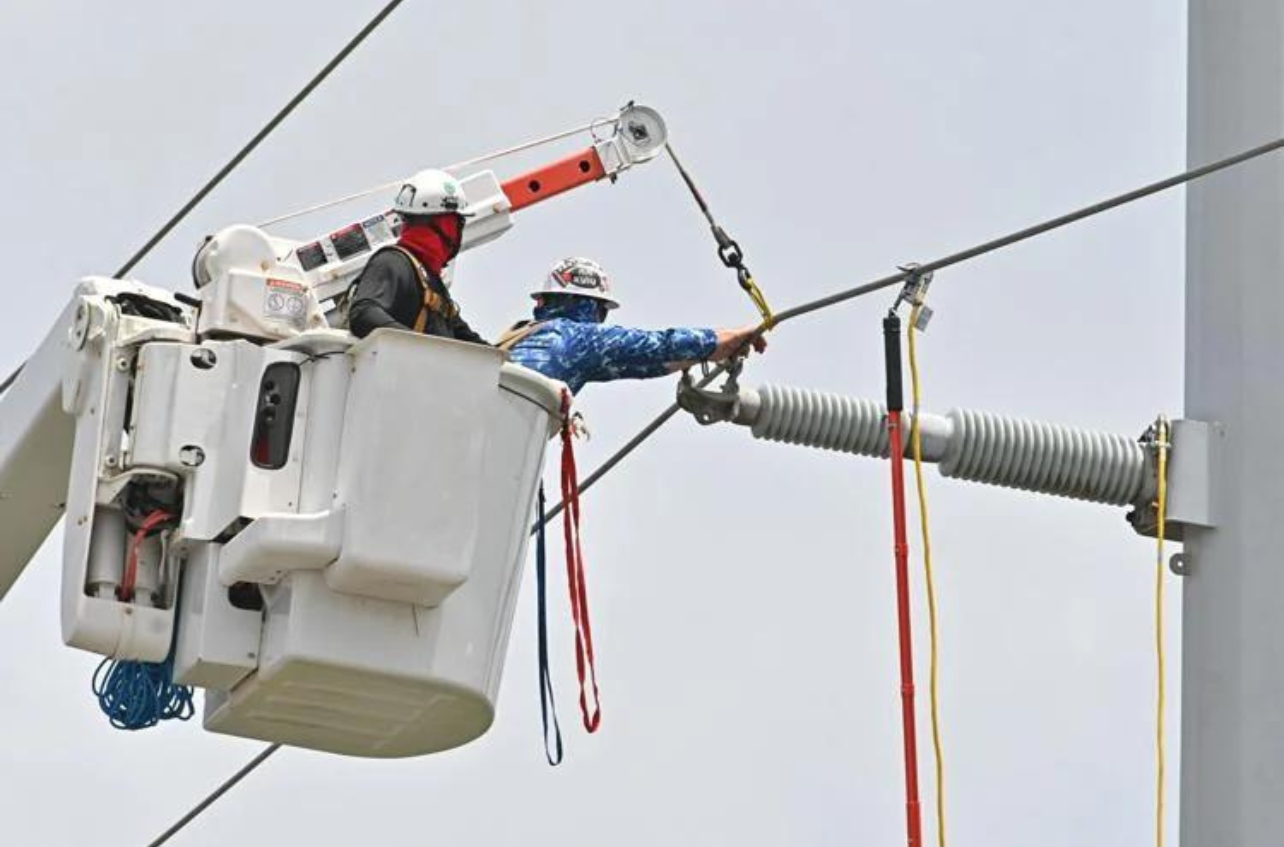 Crews from the Snohomish County Public Utility District of Washington work on 115-kilovolt transmission lines Monday, June 12, 2023, along Route 16 in Barrigada Heights.