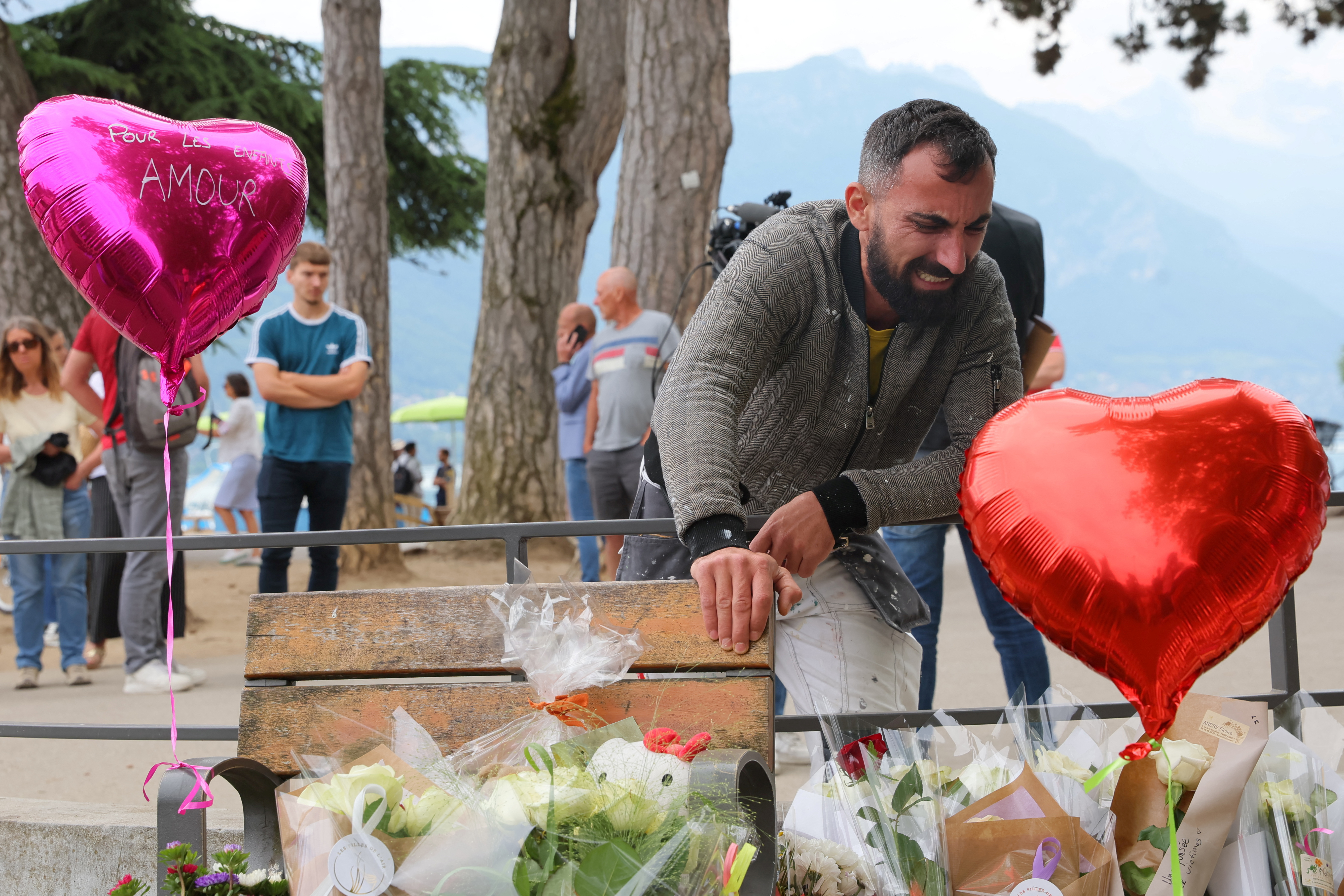 Salih Ismajl cries in front of messages and floral tributes at the children's playground the day after several children and adults were injured in a knife attack at the Le Paquier park near the lake in Annecy, in the French Alps, France, June 9, 2023. REUTERS/Denis Balibouse