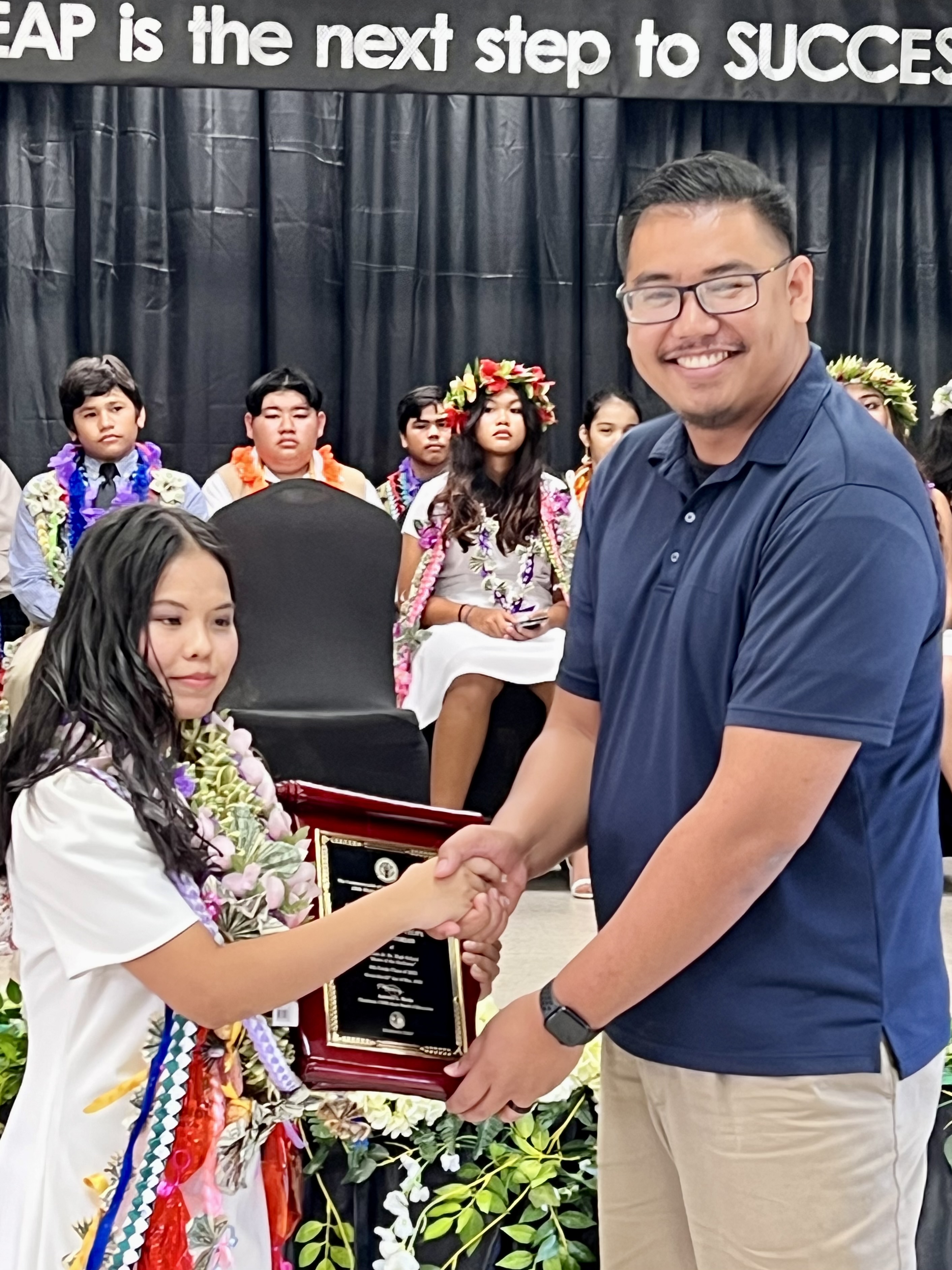 Board of Education Chairman Antonio L. Borja congratulates Alicia Wen L. Teope, the class valedictorian and Board of Education Academic Award recipient.